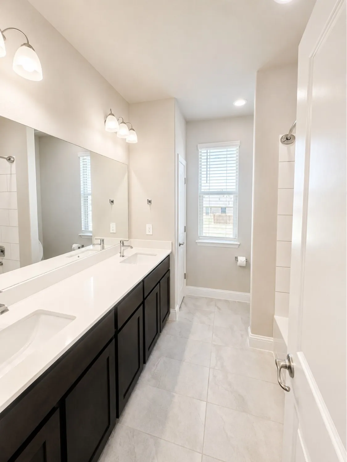 Dual vanity with integrated sinks, white countertops, and dark wood-finish cabinetry