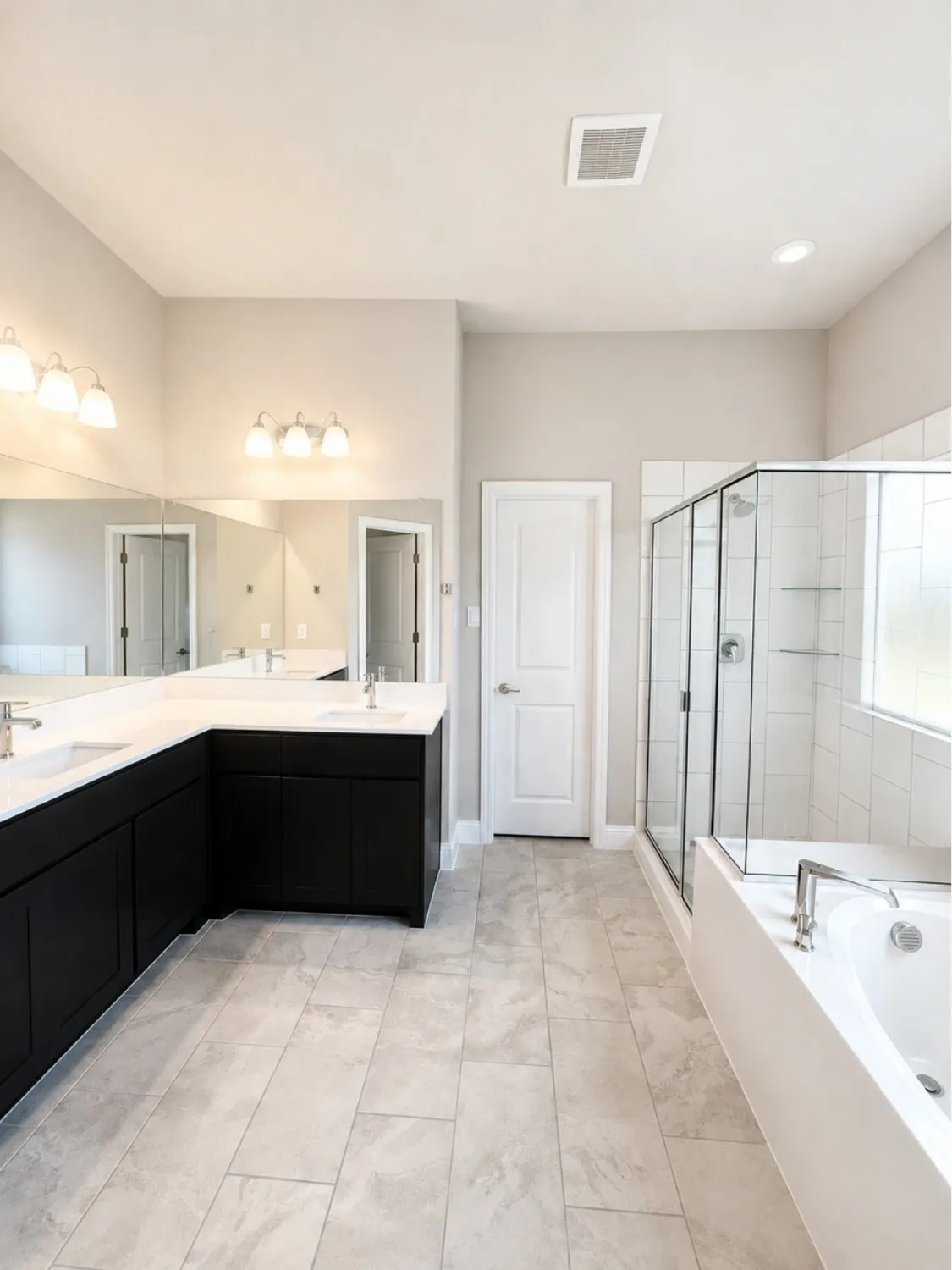 Spacious bathroom featuring an L-shaped vanity with dual undermount sinks, black cabinetry, and light-toned countertops