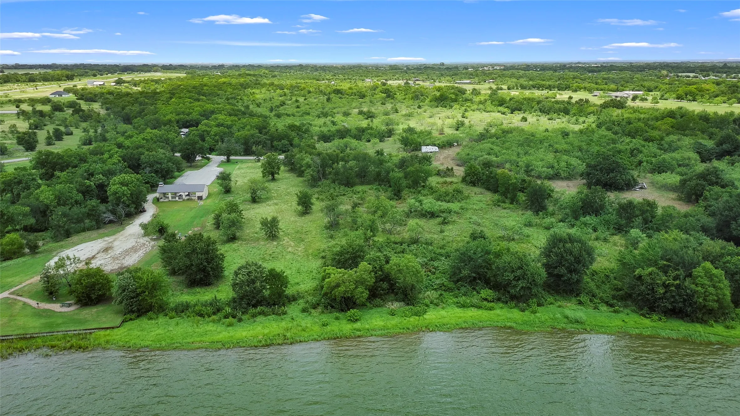 Expansive undeveloped acreage with significant tree coverage and water frontage