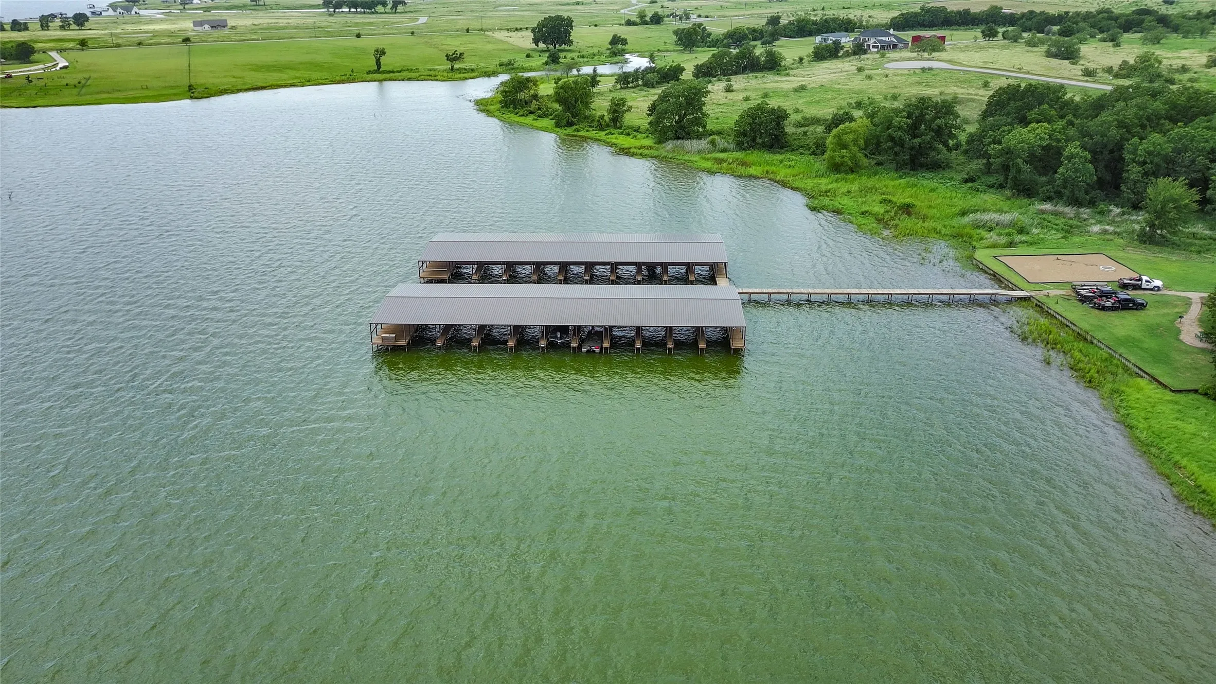 Lakefront property featuring a multi-slip boat dock, extensive waterfront, and a pier extending to the shore