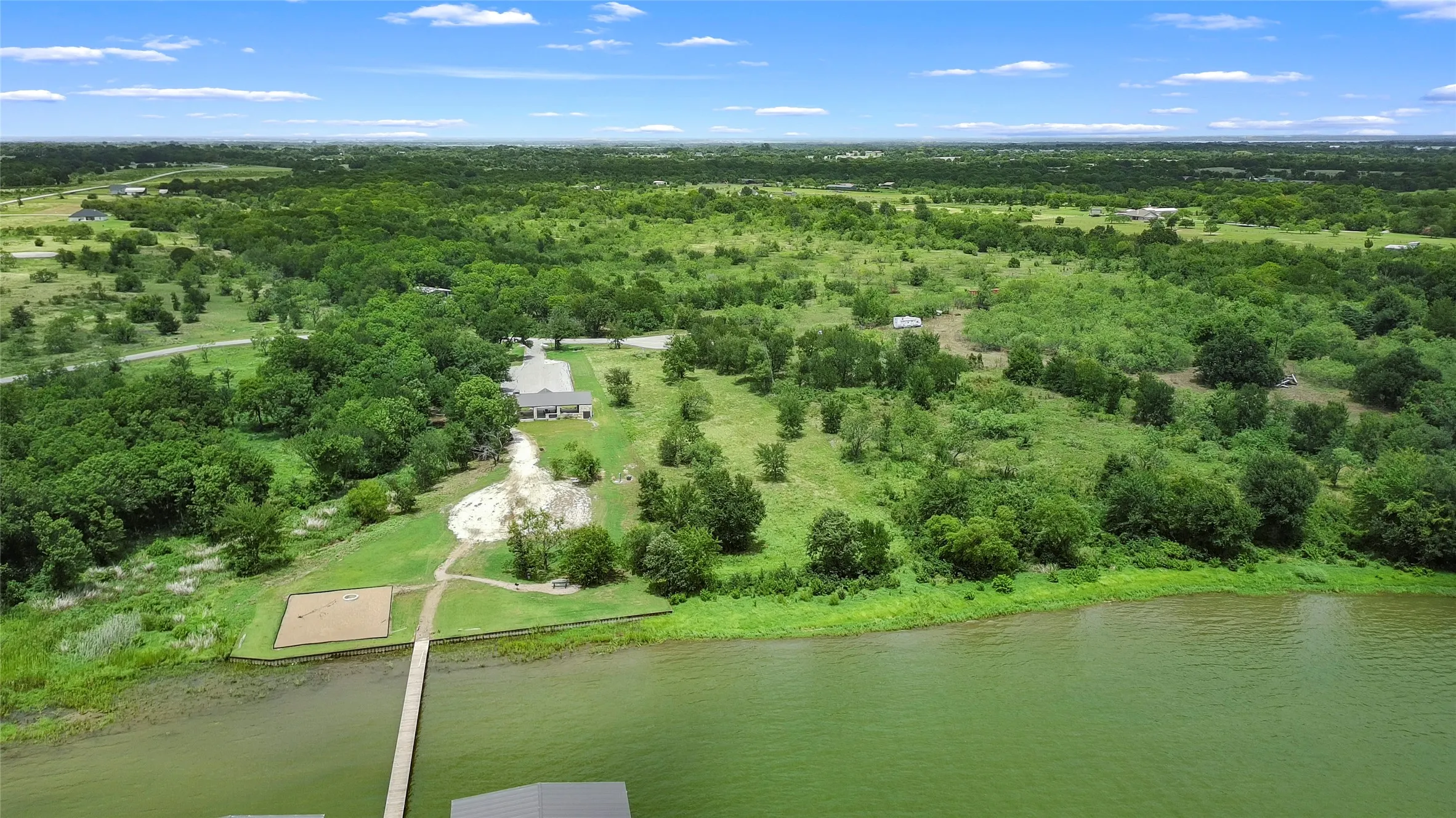 Expansive waterfront property featuring a private dock, boathouse, and a large residential structure