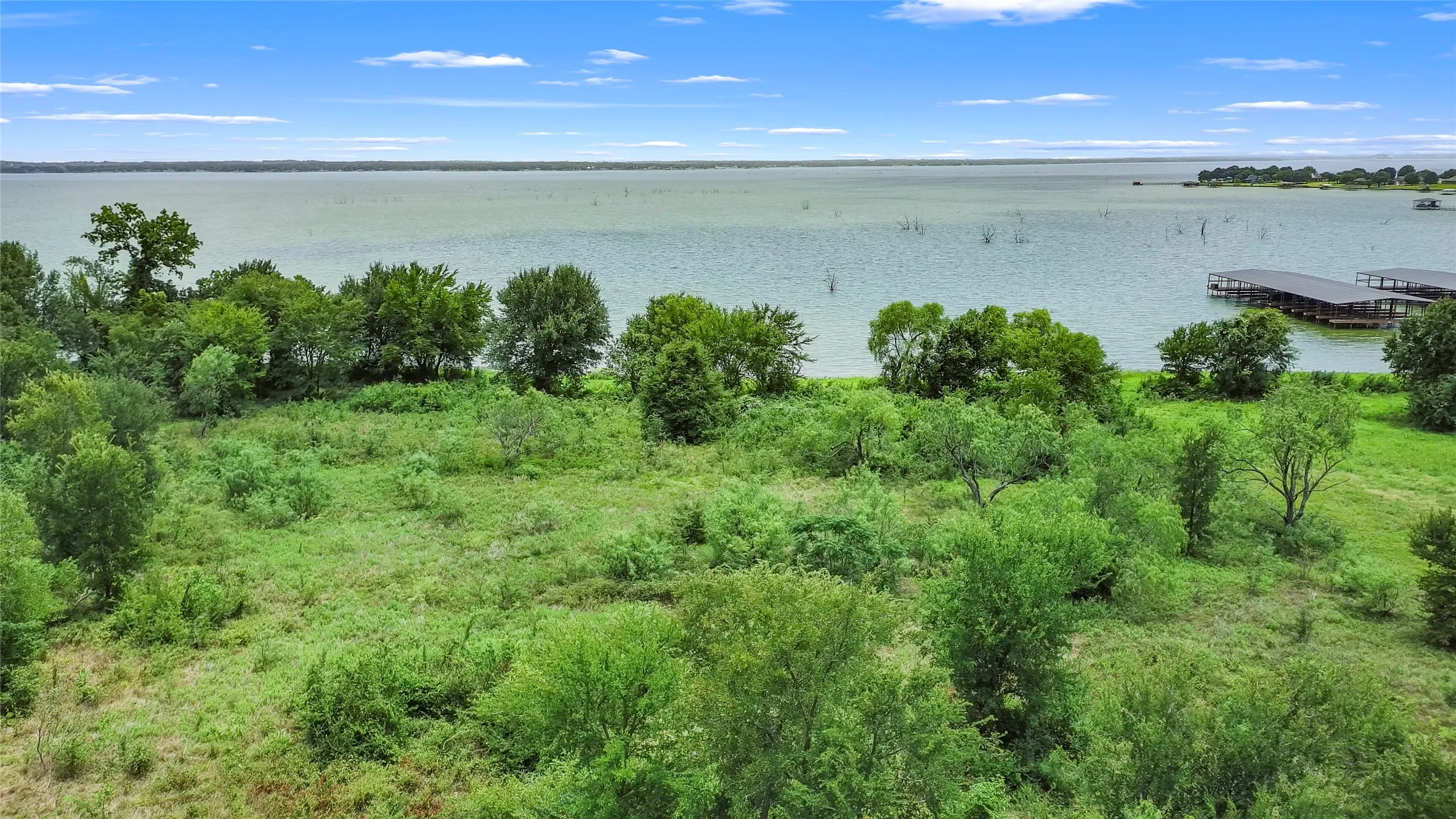 Expansive waterfront property featuring mature trees and a substantial body of water