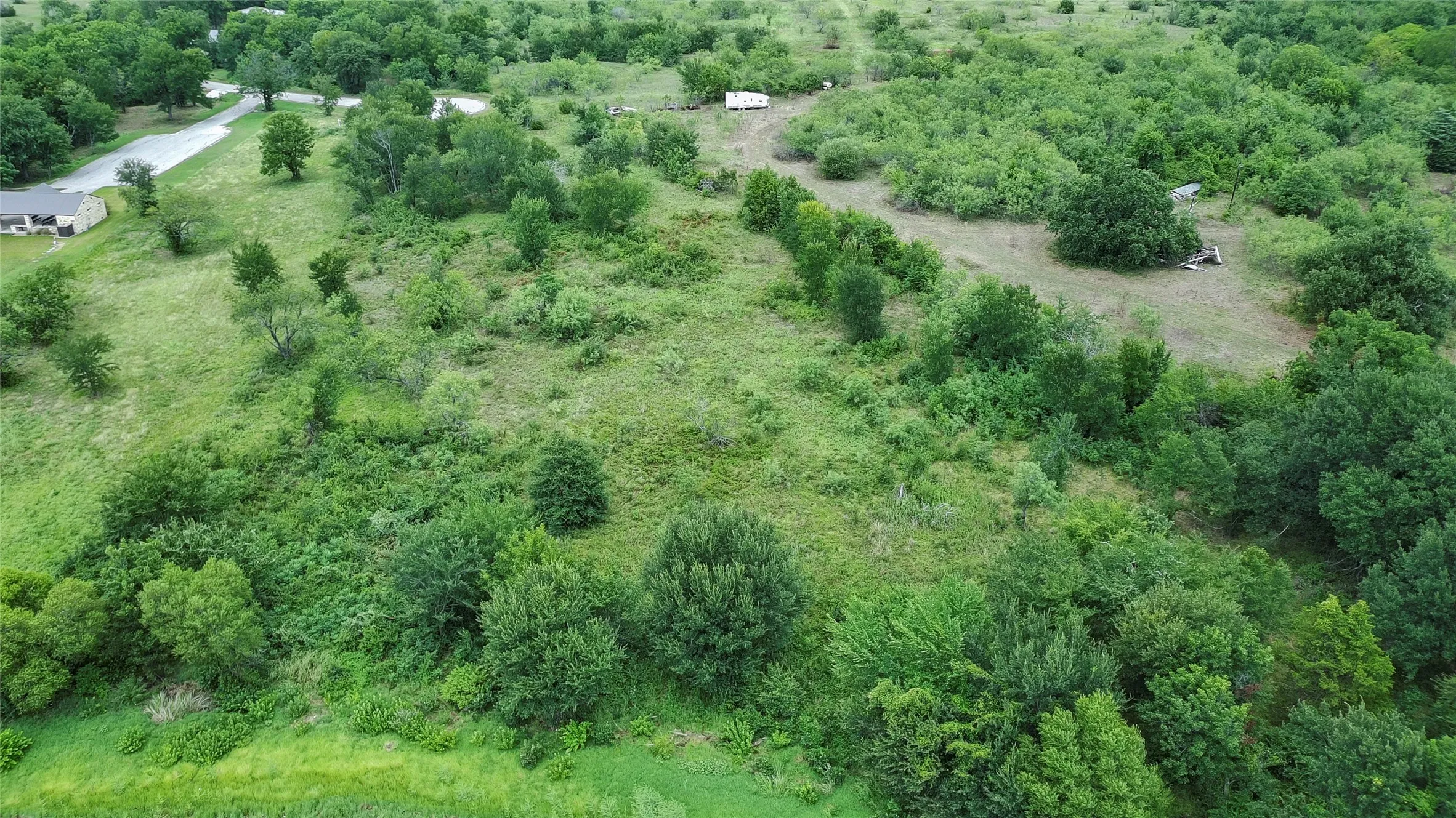 Expansive land parcel featuring varied topography, mature trees, and natural vegetation
