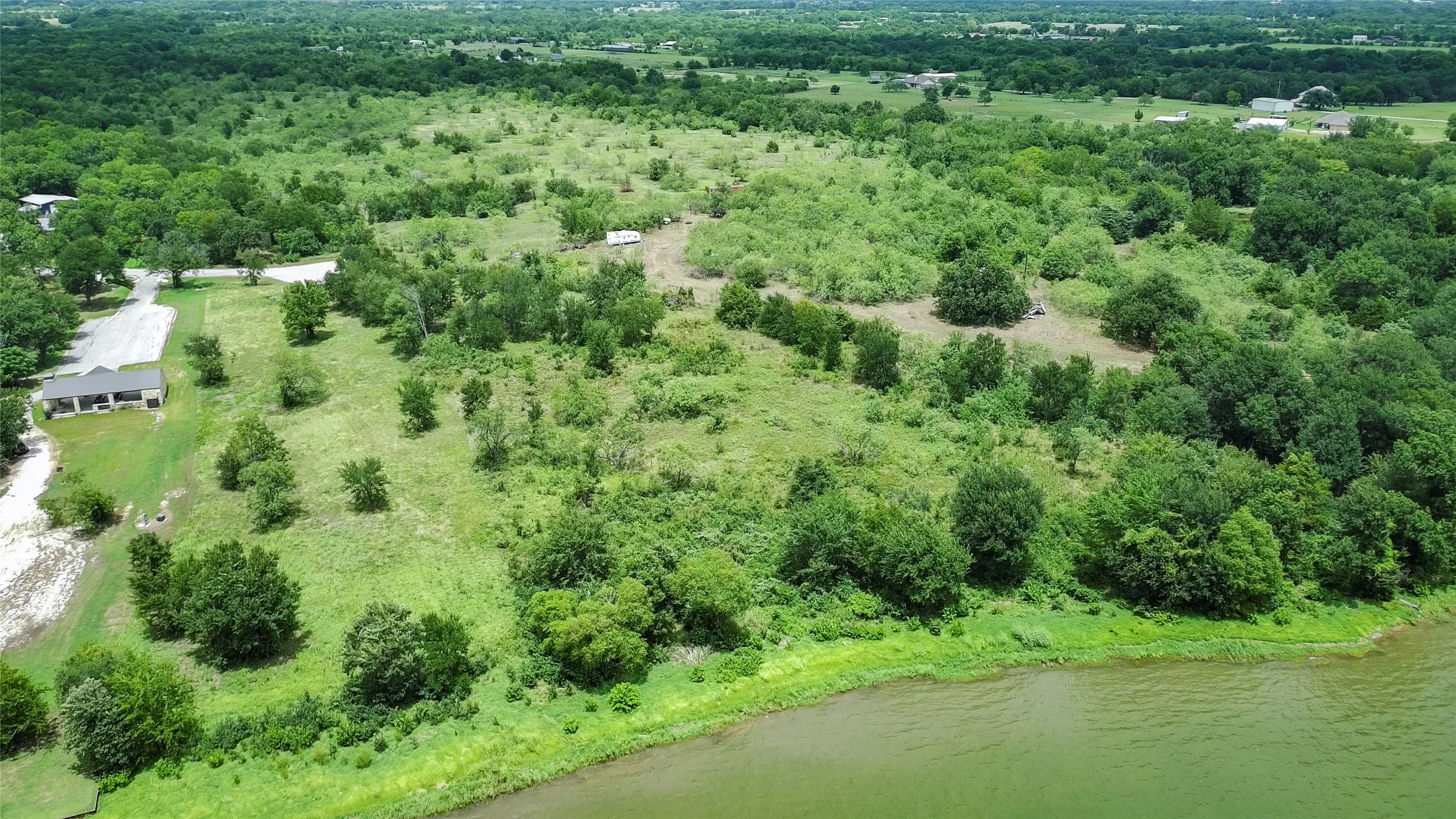 Expansive natural landscape with mature trees and varied vegetation