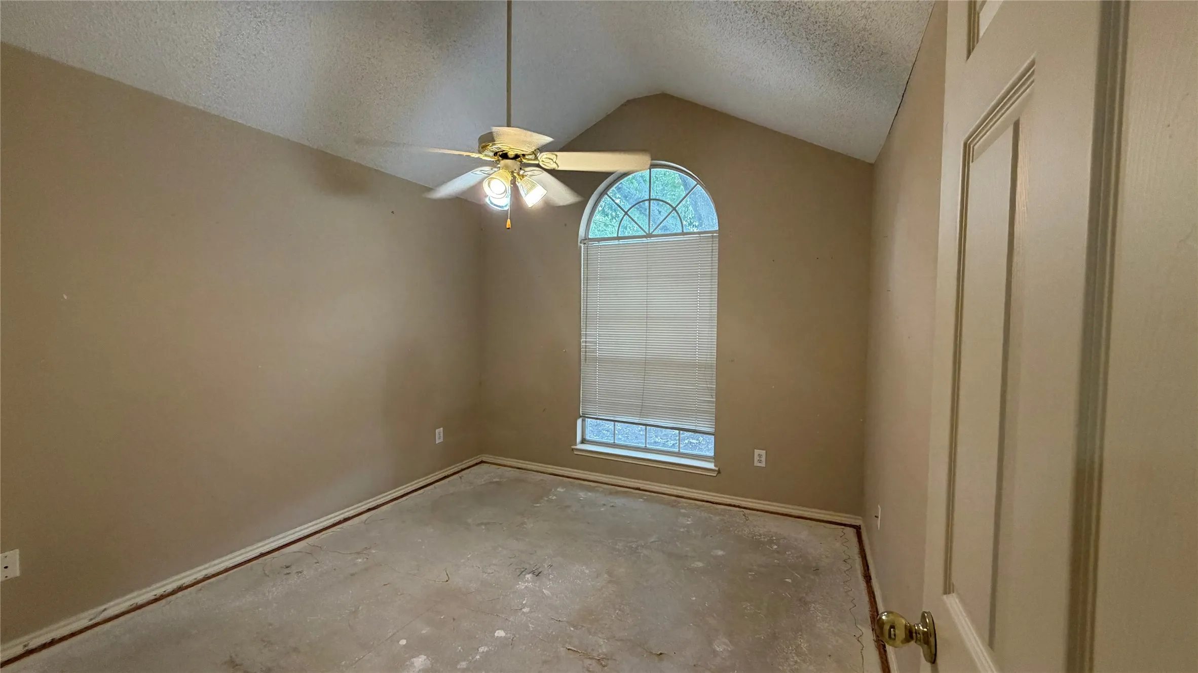 Vaulted ceiling with a ceiling fan, arched window with blinds, and neutral painted walls