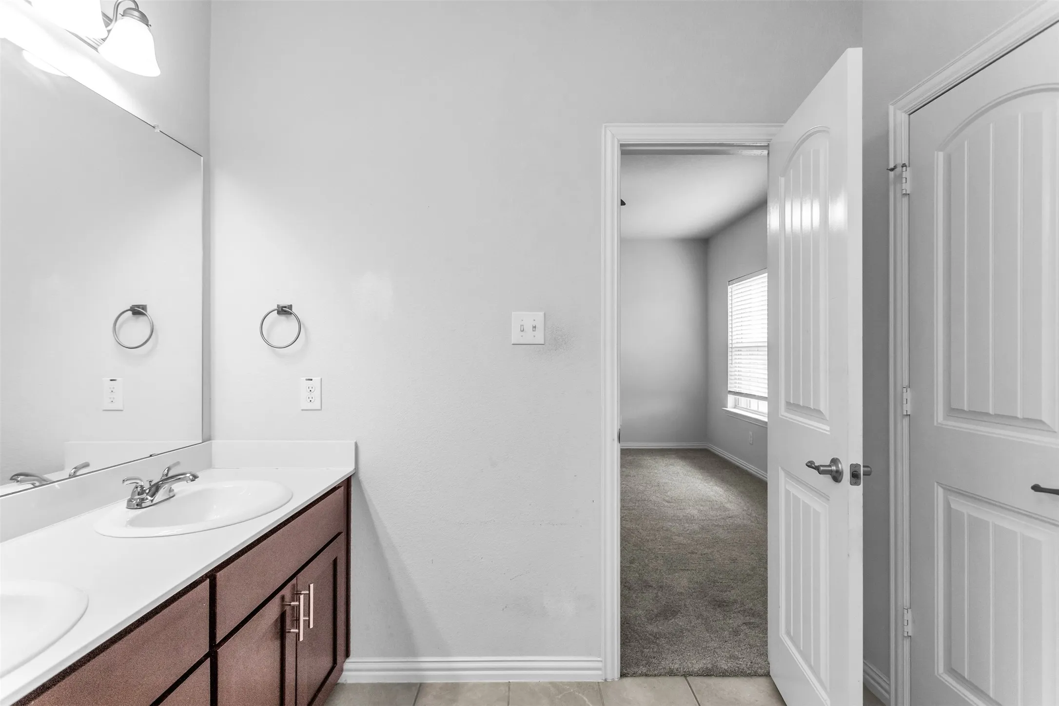 Dual vanity with white countertop and wood-finish cabinetry