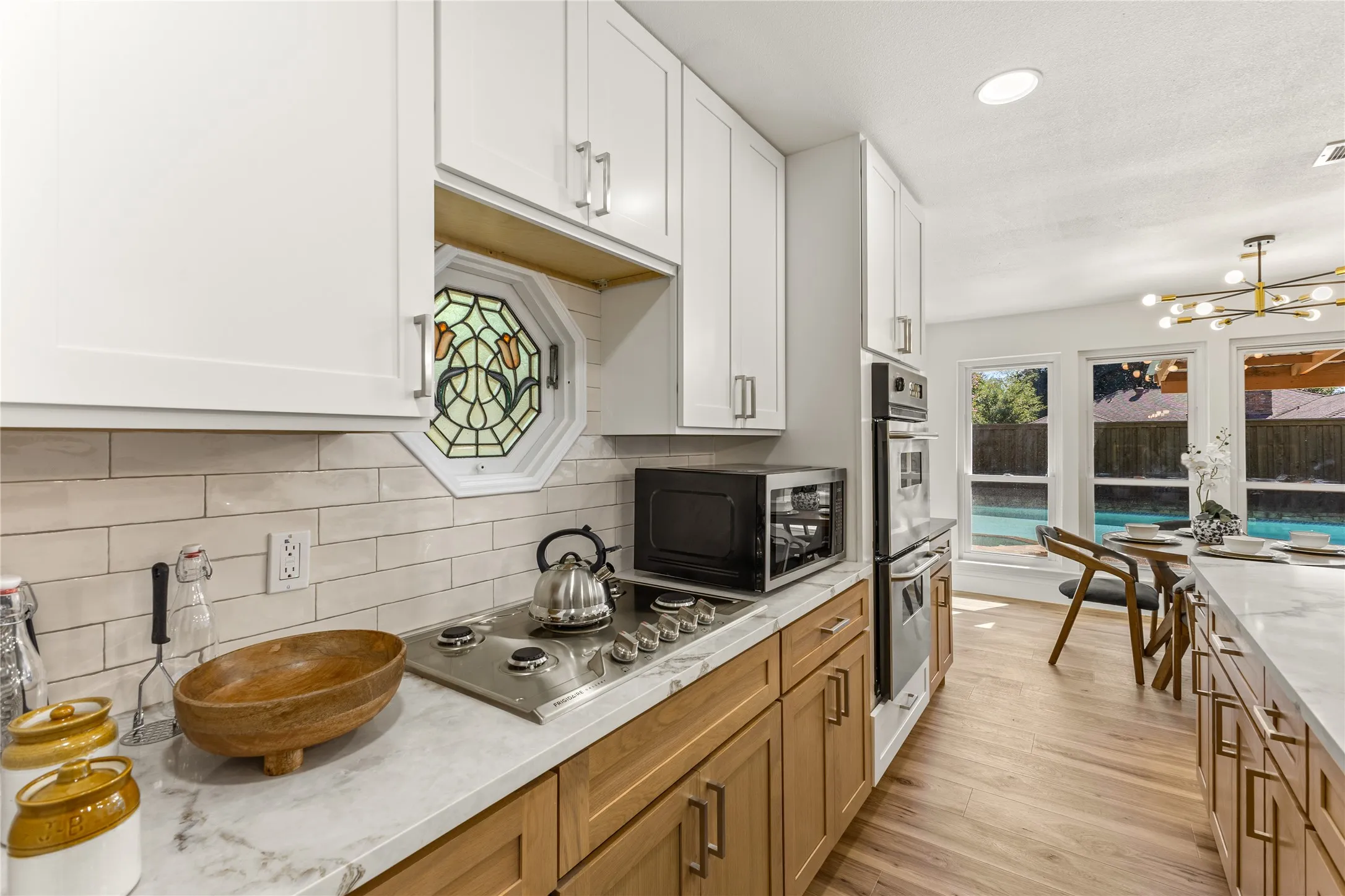 White upper cabinetry with natural wood-finish lower cabinetry