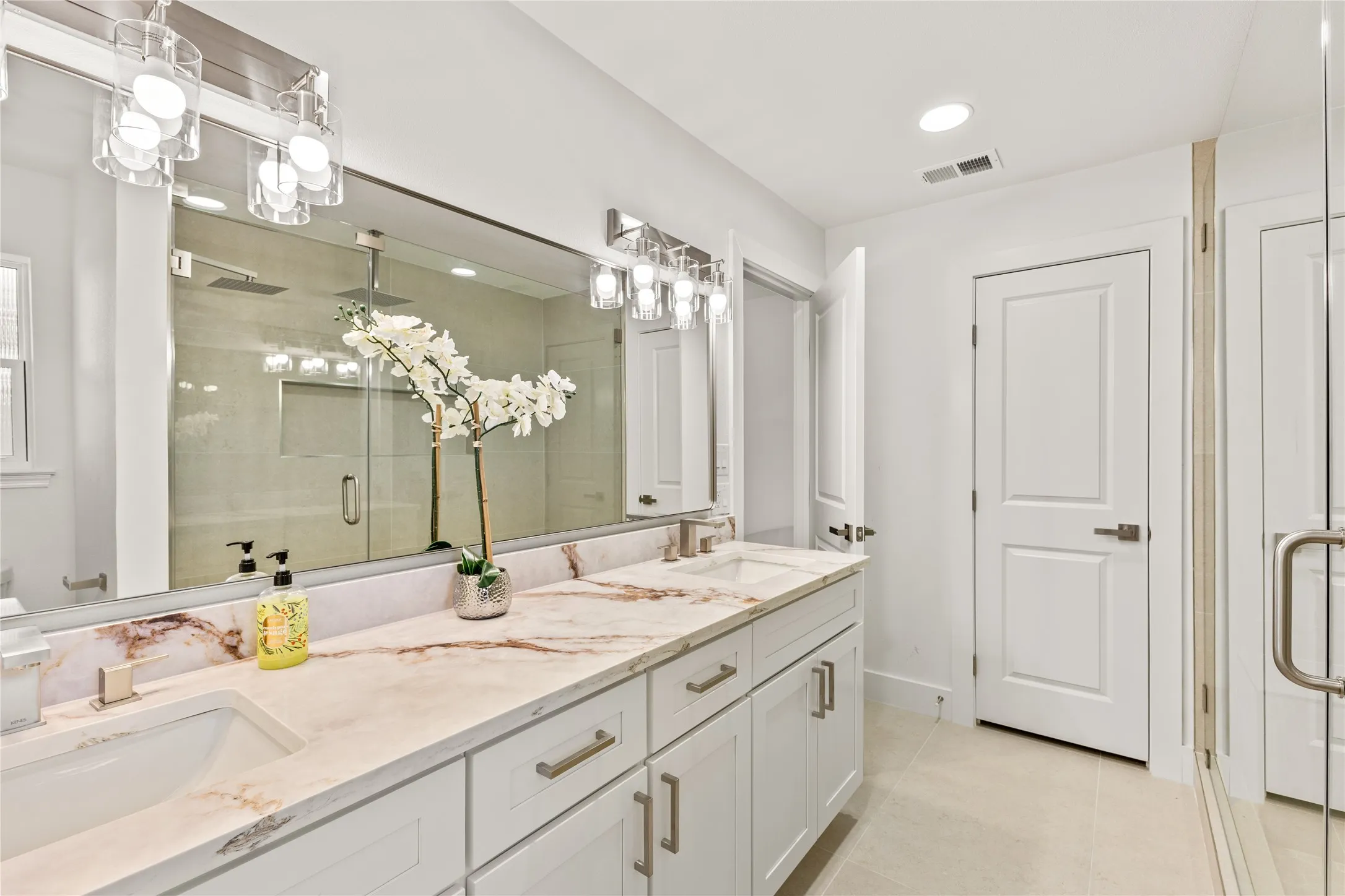Double vanity with undermount sinks, stone countertops, and brushed nickel fixtures