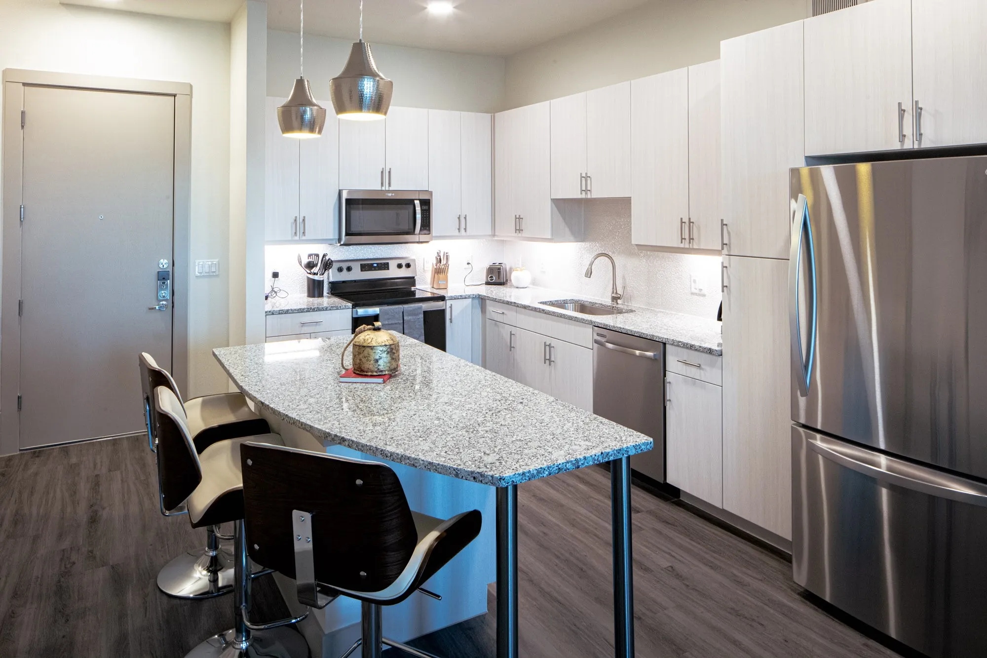 Kitchen featuring pendant lighting, white cabinets, sink, dark wood-type flooring, and appliances with stainless steel finishes