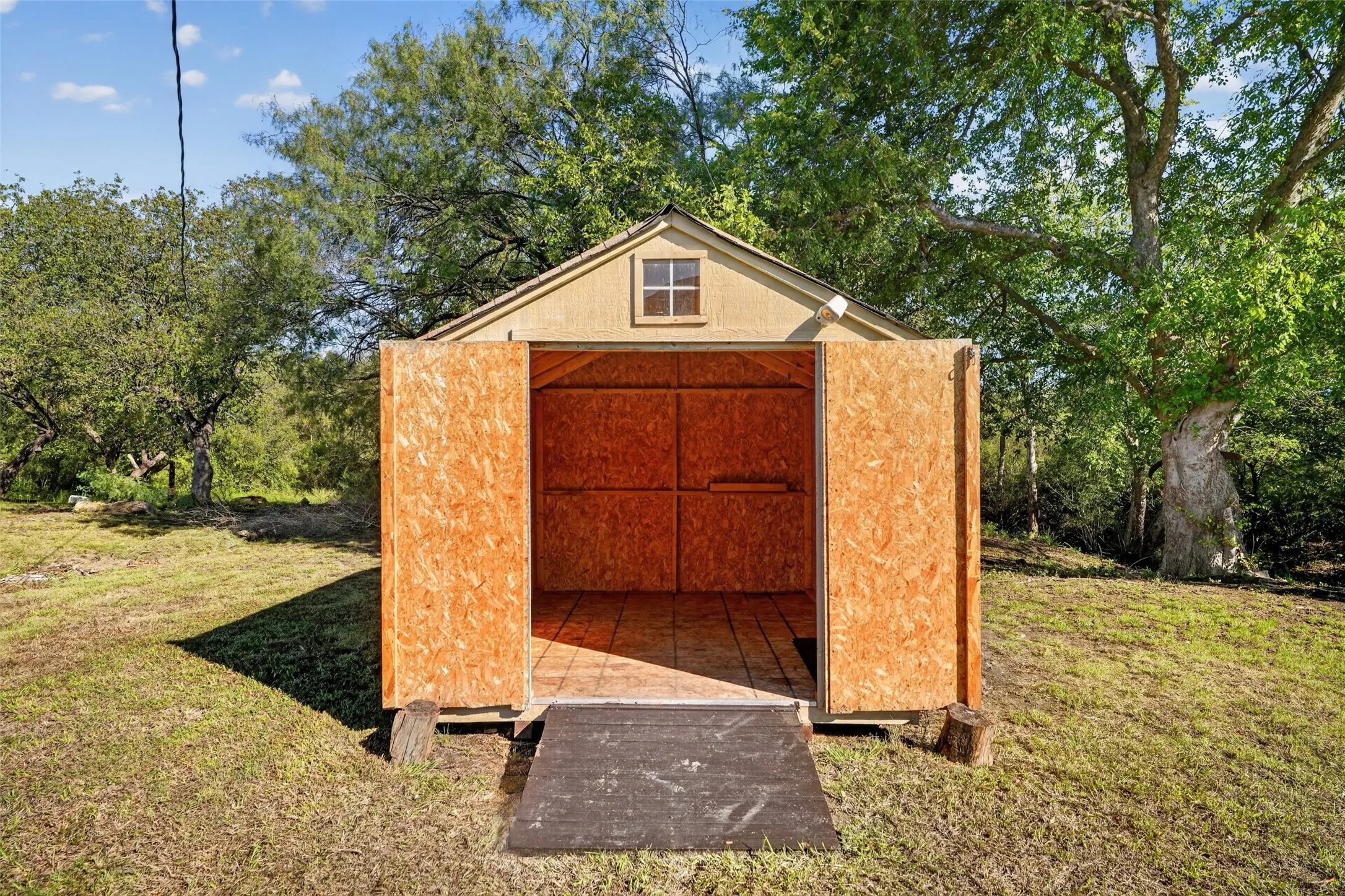 Gable-roofed outbuilding with a single window and double doors