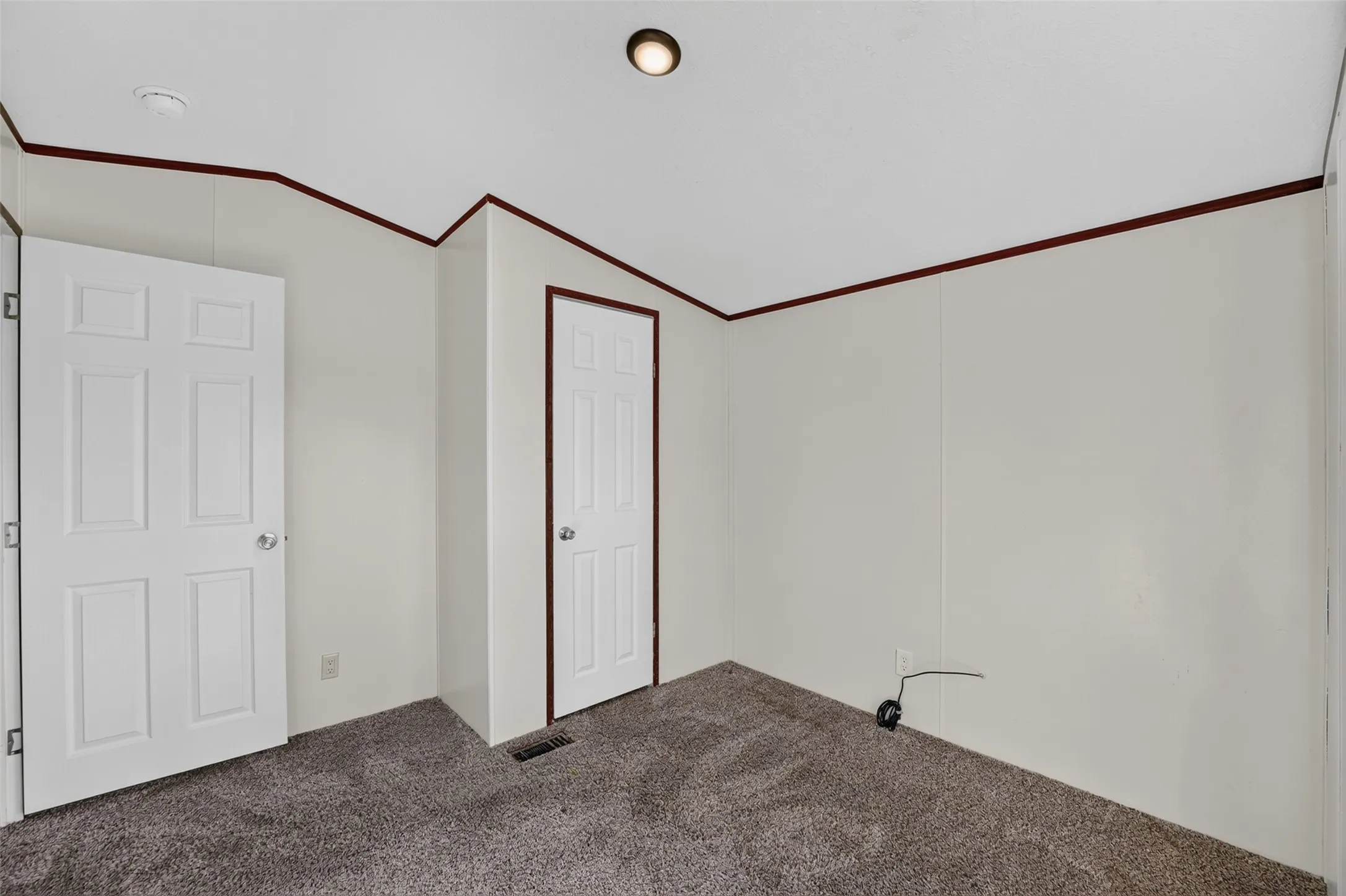 Recessed ceiling light, paneled doors, wall molding, and carpeted flooring