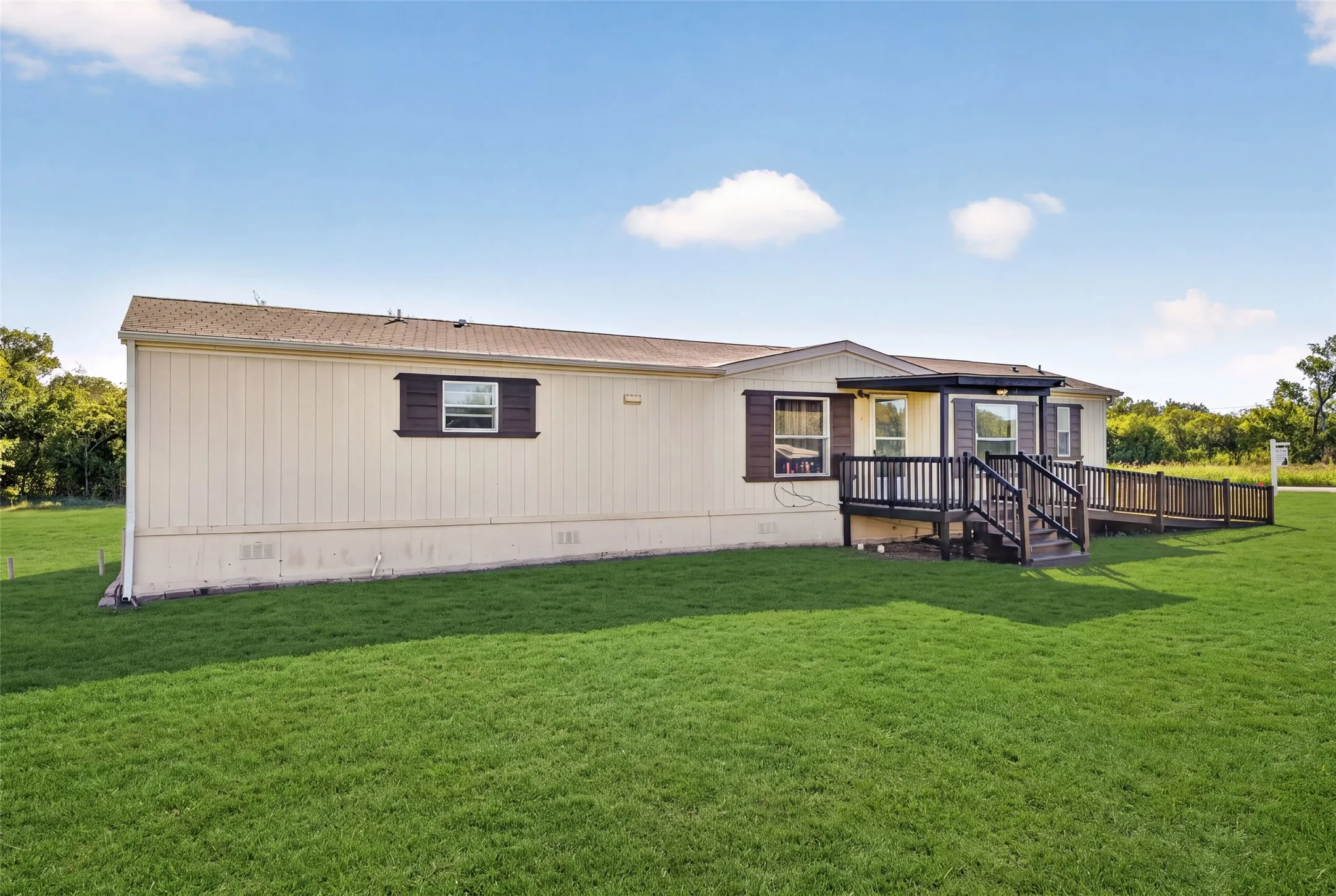 Exterior siding with architectural shutters, covered entry with porch, and an accessible ramp
