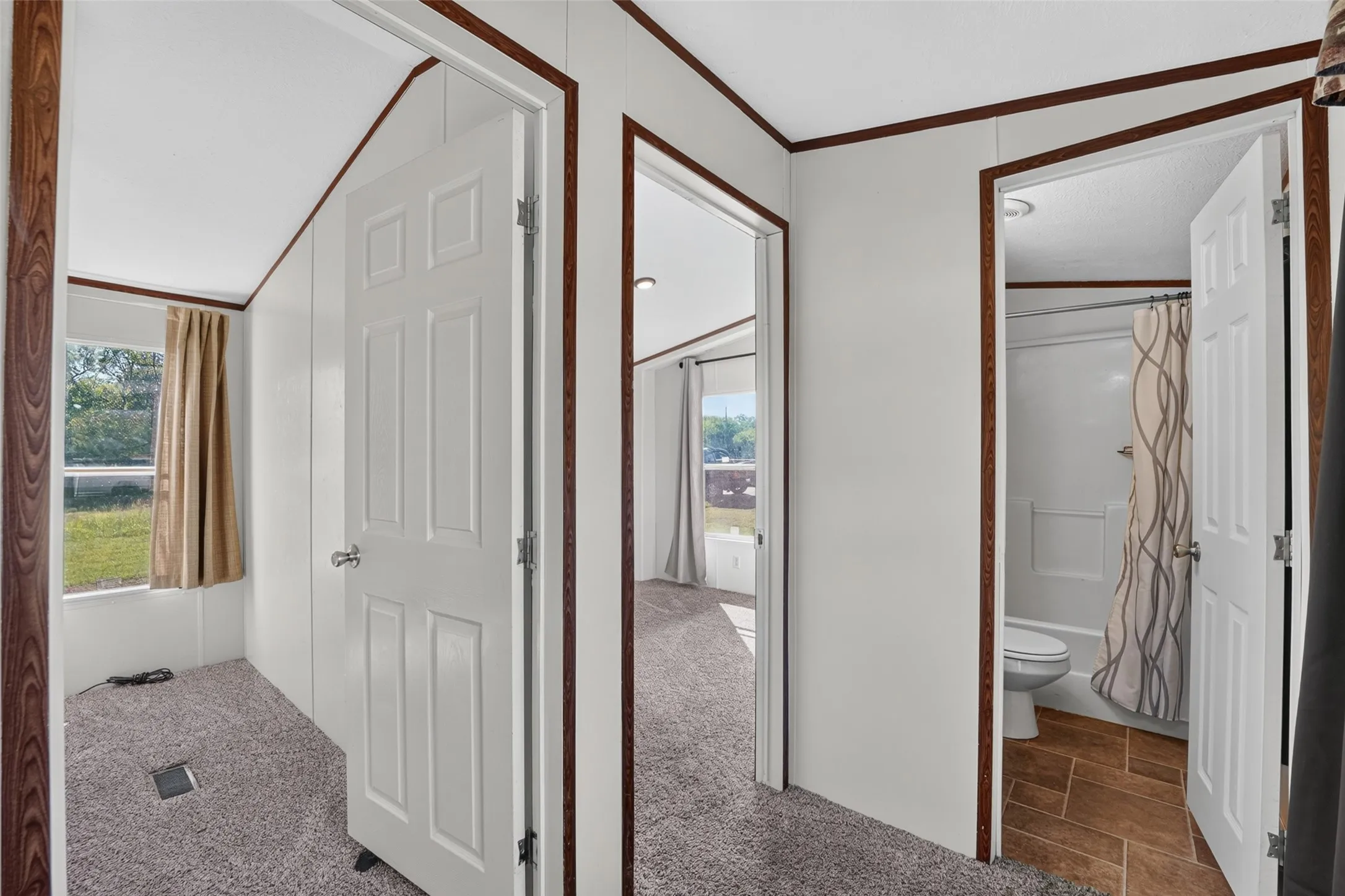 Textured gray carpeting, white interior doors, and wood-finish trim accents