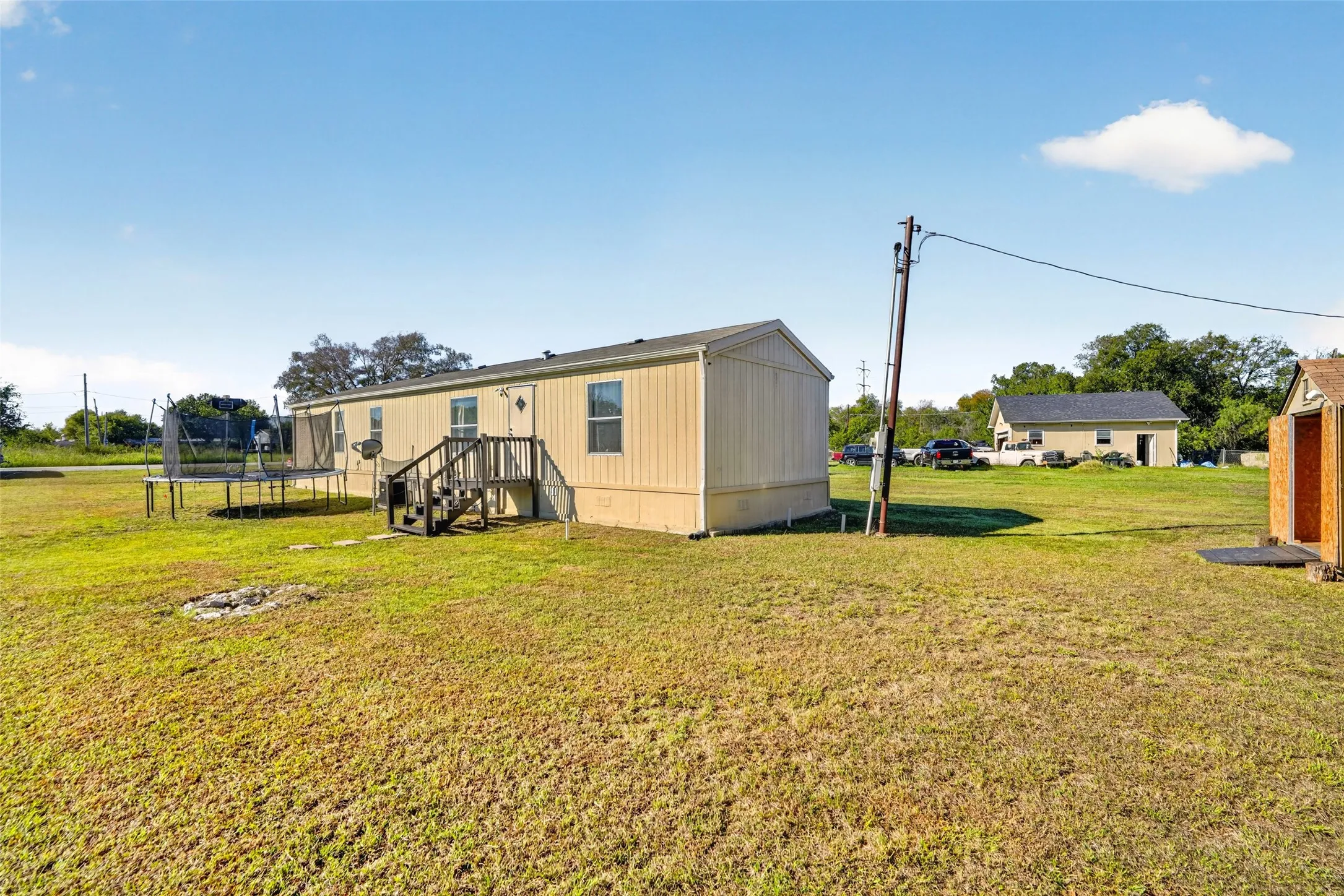 Expansive grassy grounds with a separate storage shed and an additional detached structure