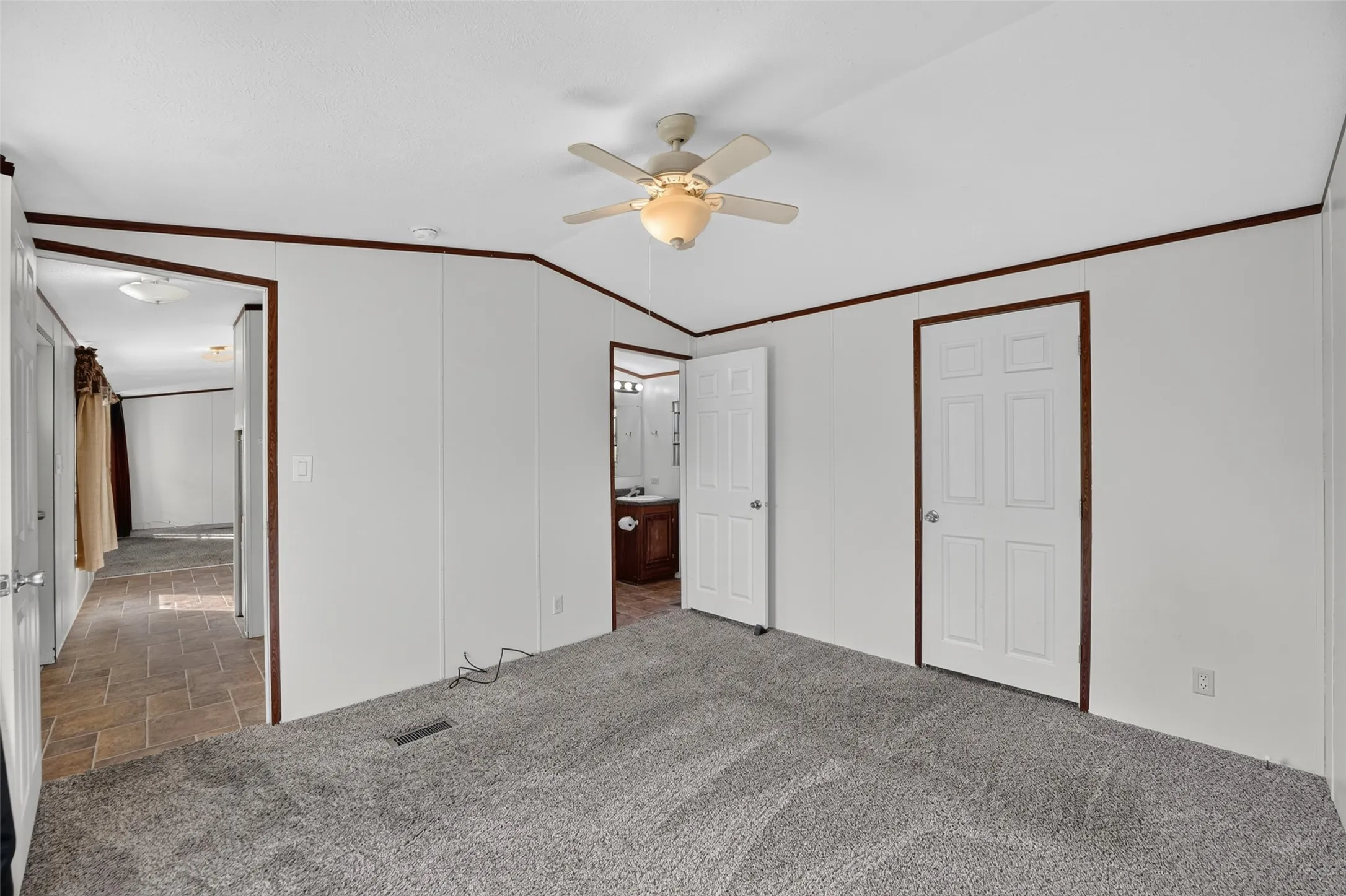 Plush carpet flooring, ceiling fan with integrated lighting, paneled interior doors, and wood-finish trim
