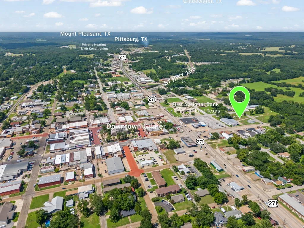 Aerial perspective of a developed area featuring a major roadway and surrounding commercial and residential structures