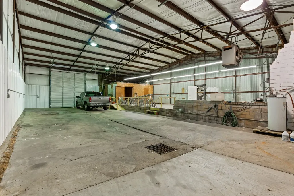 Spacious interior with concrete flooring and exposed metal beam ceiling