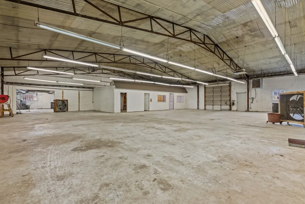 Expansive concrete flooring with a corrugated metal ceiling and exposed metal trusses