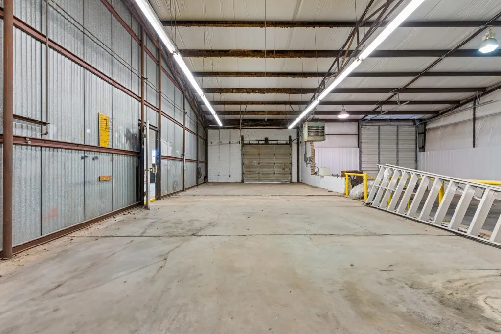 Expansive concrete flooring with corrugated metal wall paneling and exposed structural beams