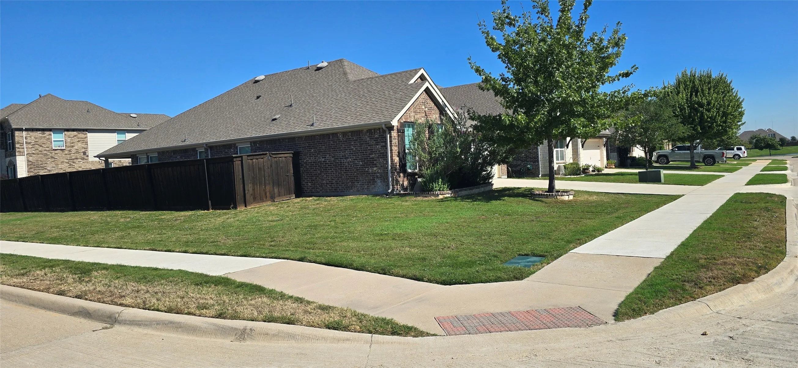 Brick exterior with a gabled roof and a private wood fence