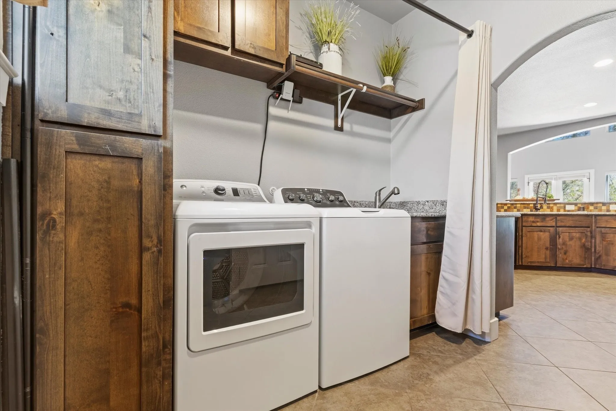 Integrated laundry area featuring white appliances, a utility sink, and granite-look countertop