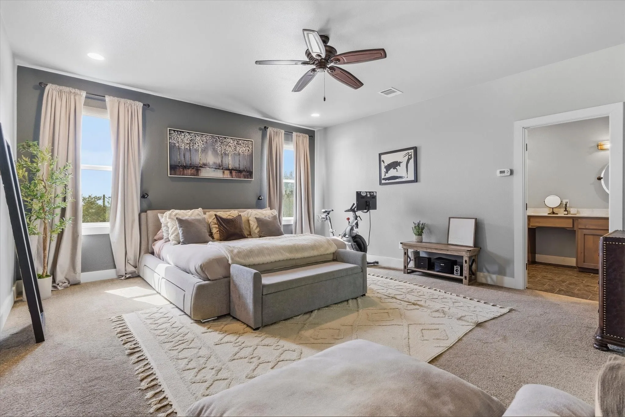 Recessed ceiling lighting, ceiling fan, and multiple windows with drapery