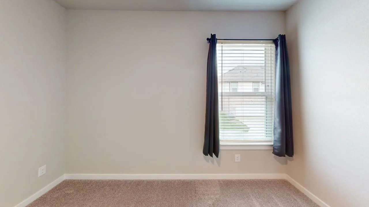 Wall-to-wall carpeting with light neutral paint throughout, featuring a double-hung window with blinds