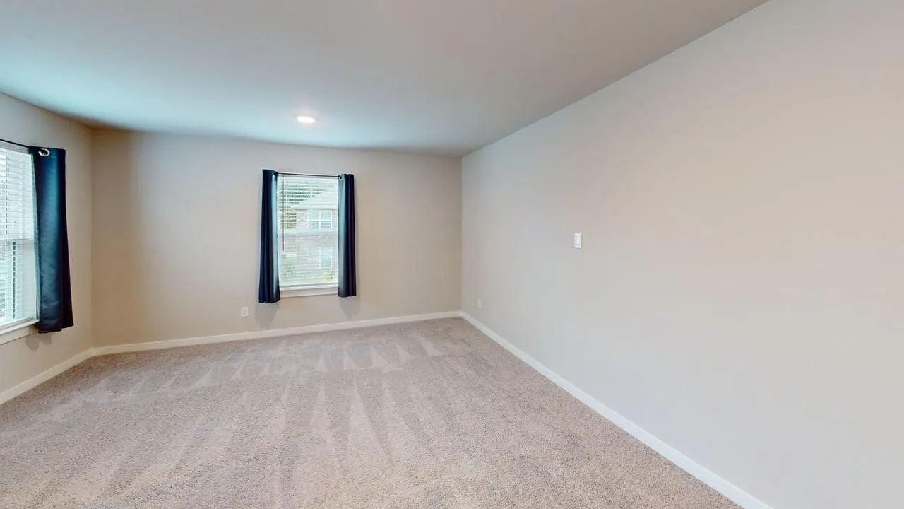 Neutral wall color, recessed lighting, and soft carpet flooring