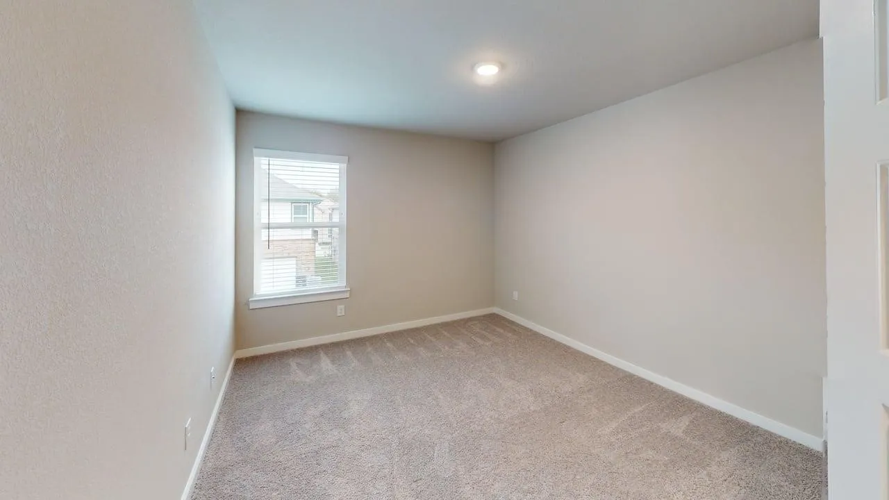 Wall-to-wall carpeting with a neutral finish, interior walls with a neutral finish, and a window with blinds