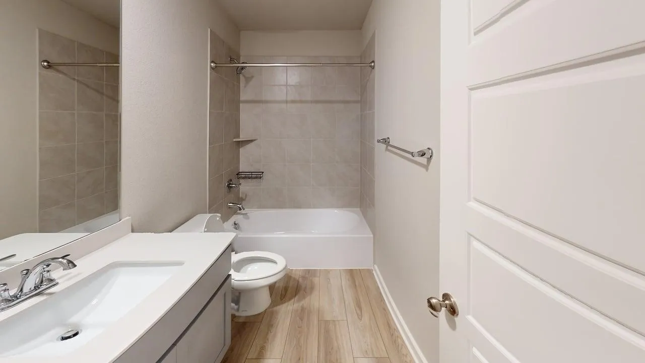 Wood-finish flooring with a white vanity featuring a rectangular undermount sink and chrome faucet