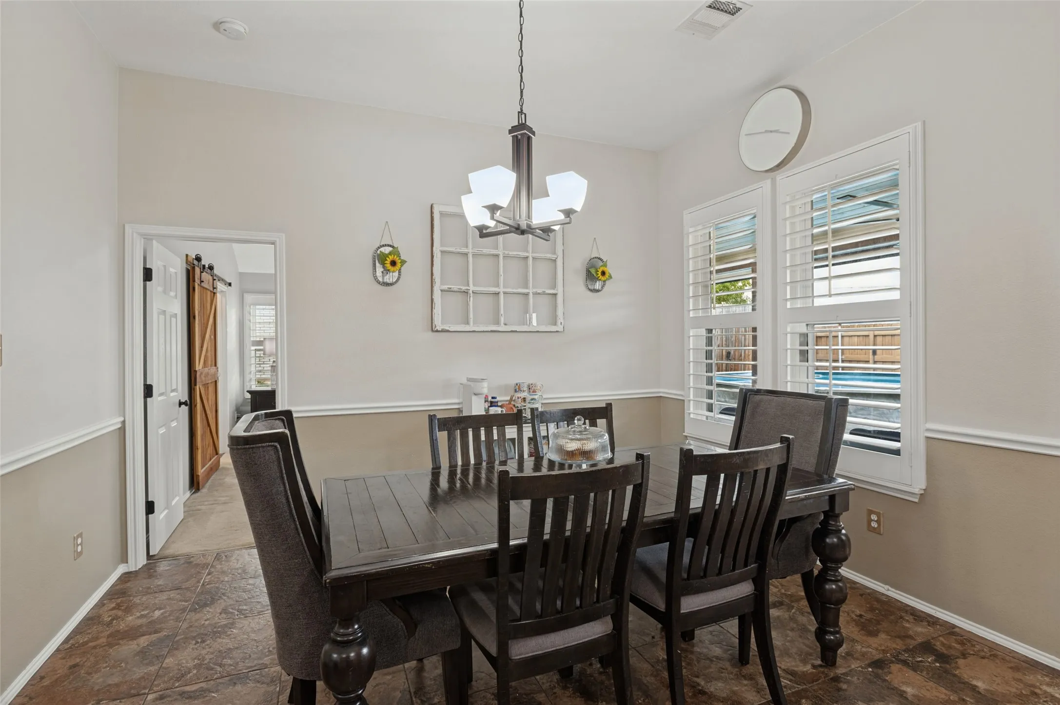 Vaulted ceiling with an attached chandelier, crown molding, and wainscoting