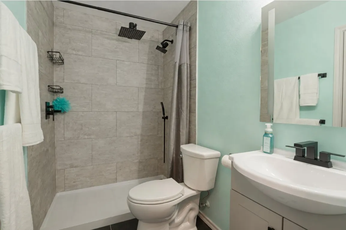Shower with tile surround, rainfall showerhead, and handheld spray