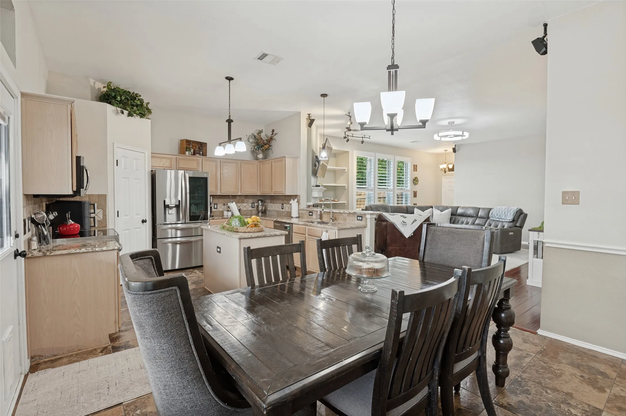 Kitchen featuring stainless steel appliances, light-toned cabinetry, and an eat-at island