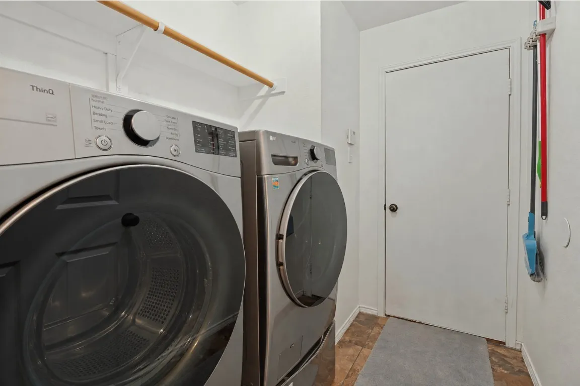 Laundry area featuring an overhead hanging rod and patterned floor tiles