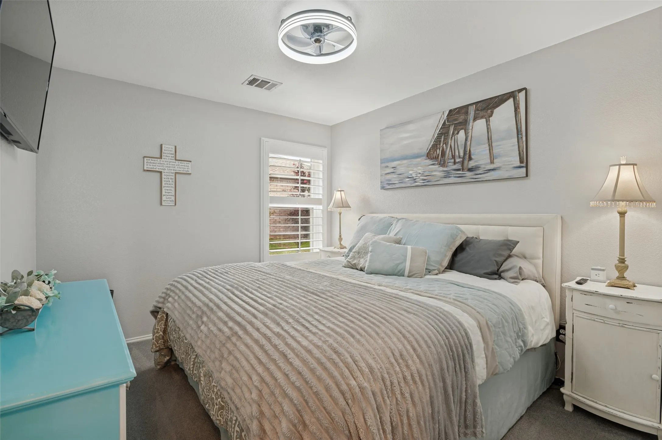Wood-finish flooring, white walls, and a window with plantation shutters