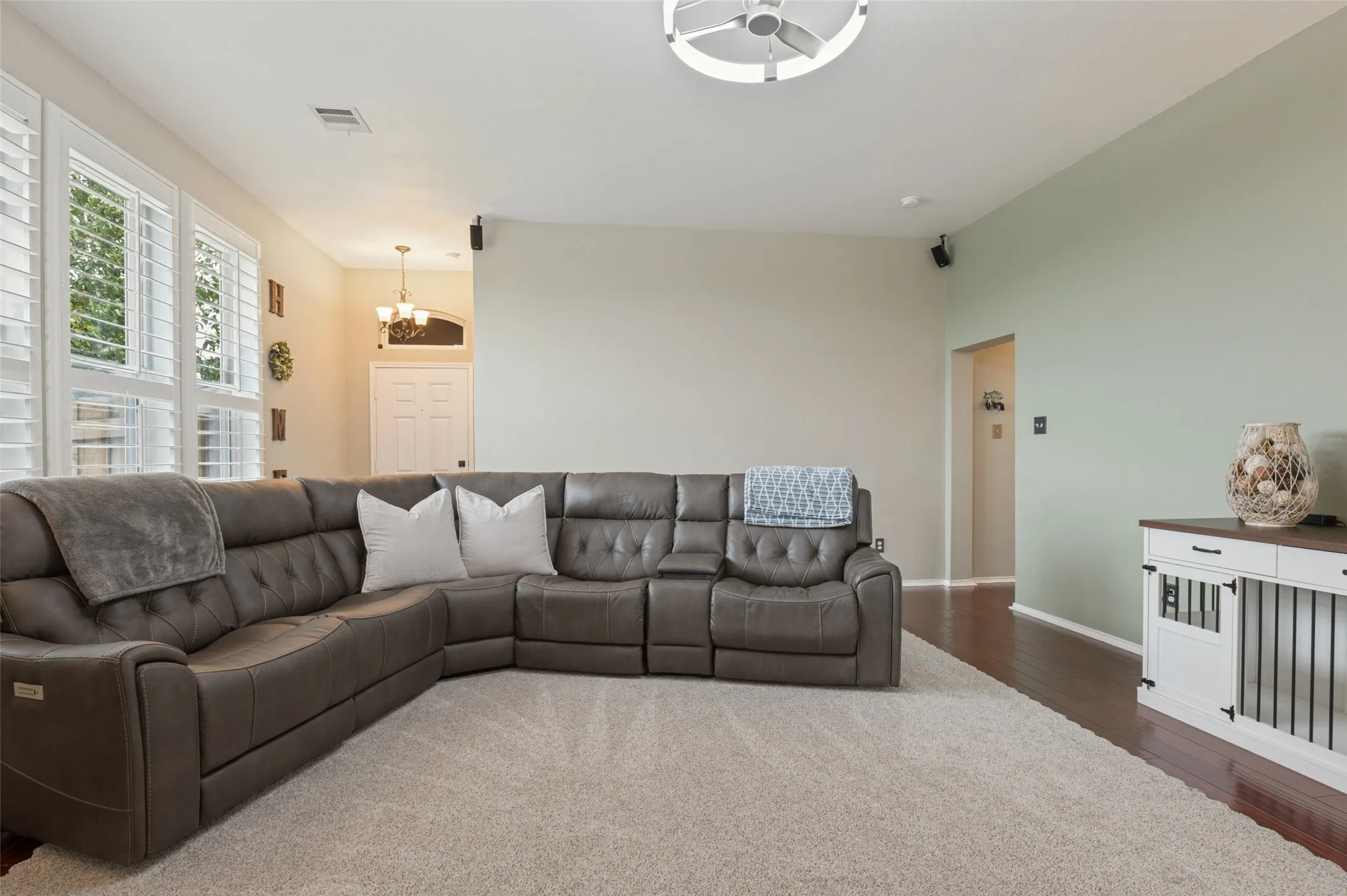 Hardwood-style flooring with area rug, plantation shutters, and recessed lighting