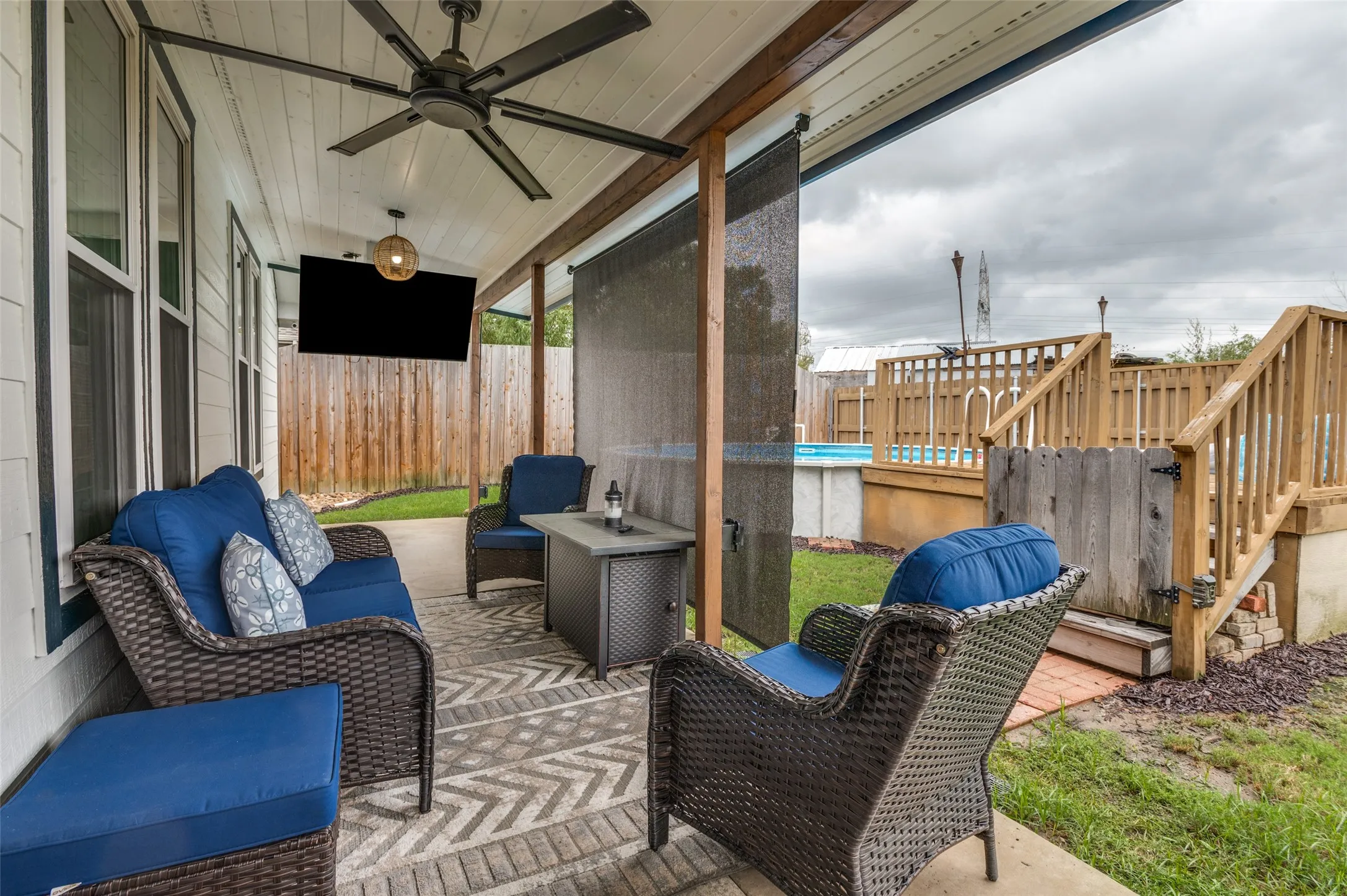 Covered patio with a beadboard ceiling, wood-beam accents, and a ceiling fan