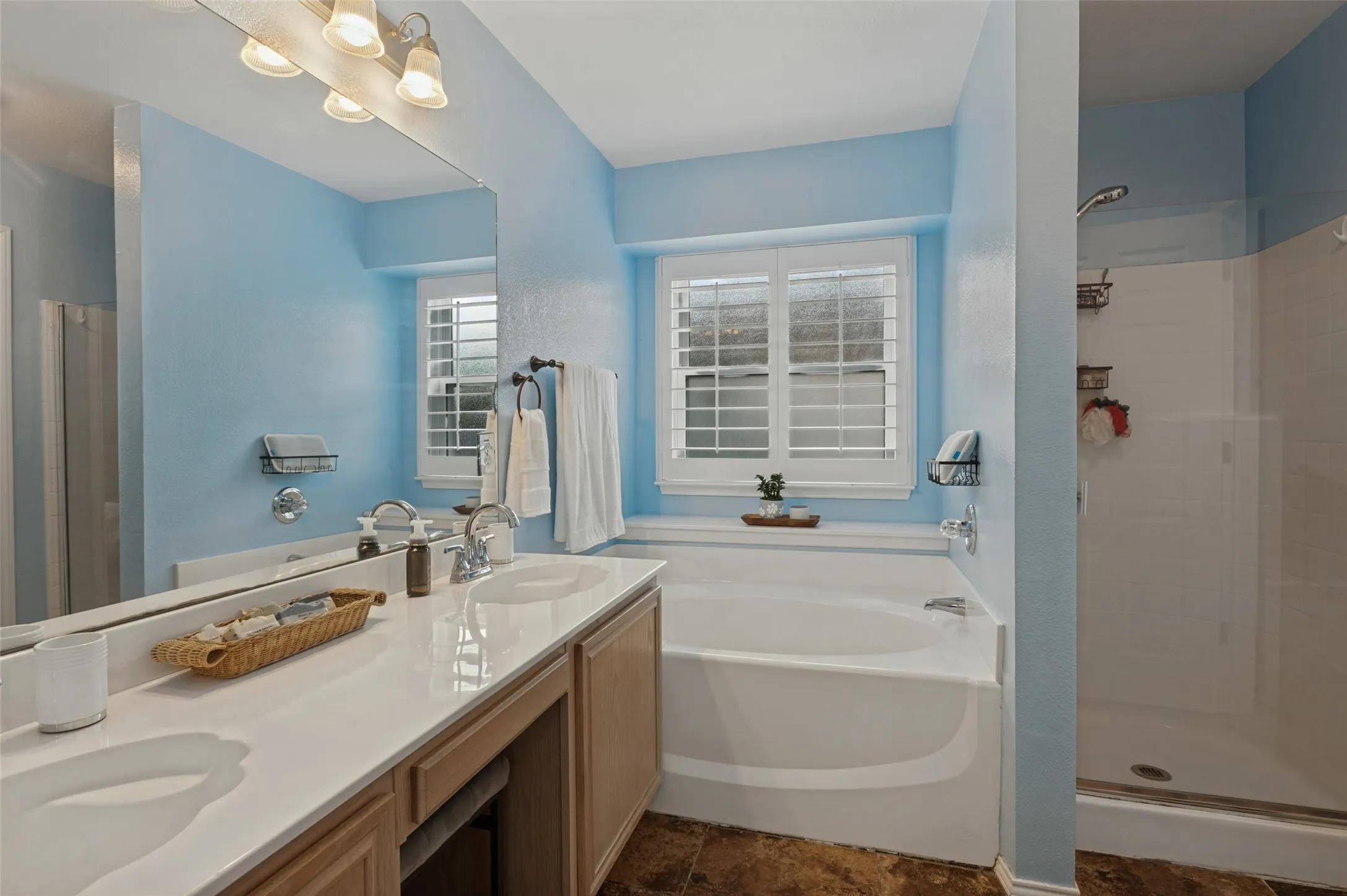 Double vanity with integrated sinks, white countertop, and wood-finish cabinetry