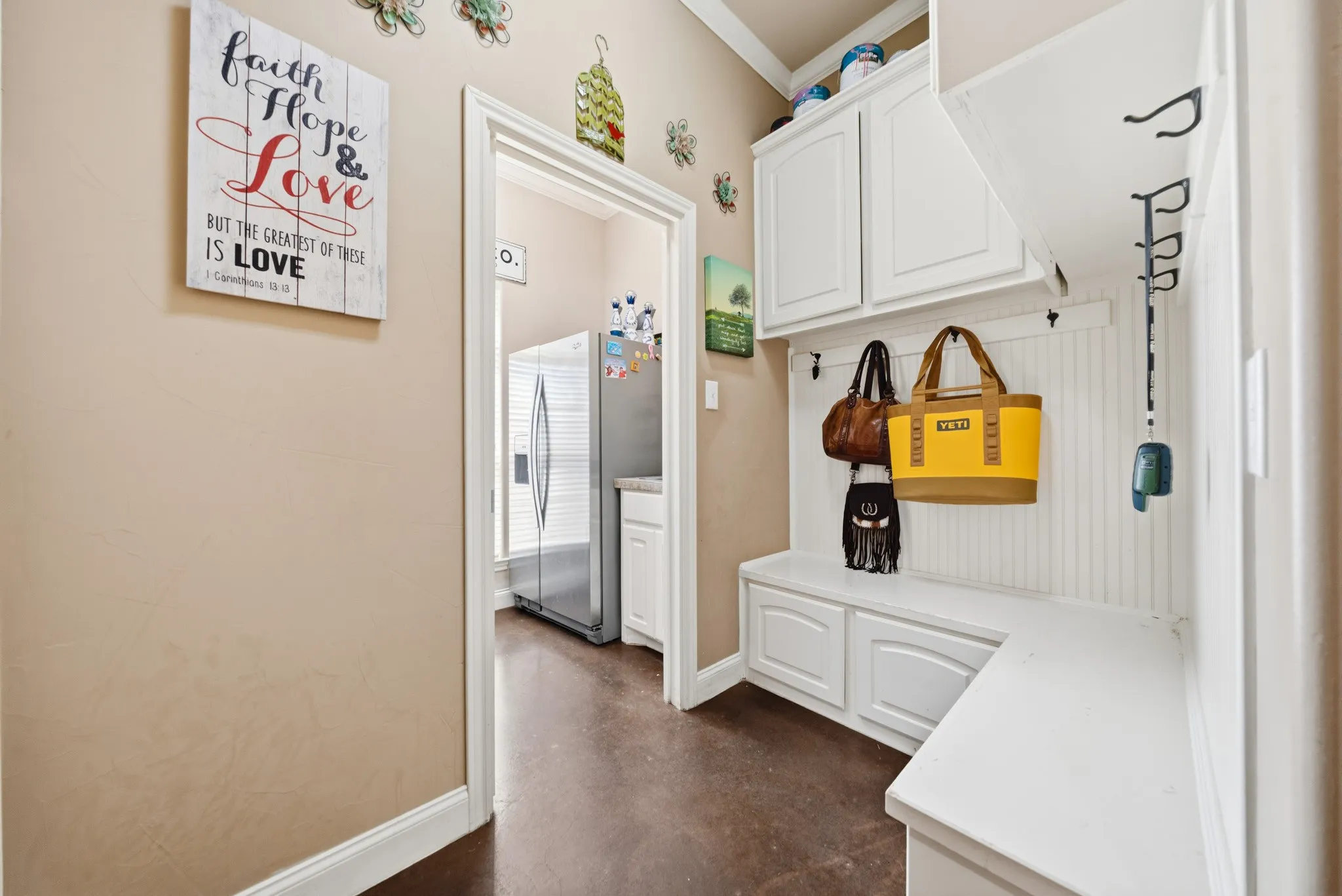 Built-in bench seating with storage, white shaker-style cabinetry, and dark wood-finish flooring