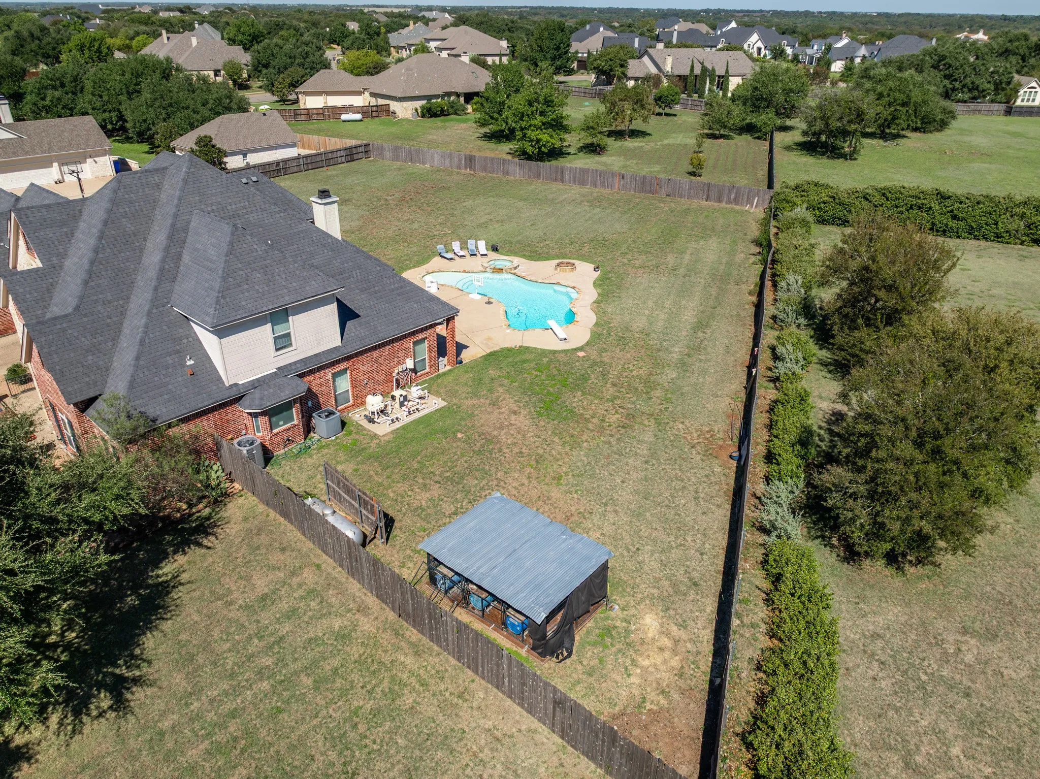 Brick exterior with a dark shingle roof and multiple chimneys
