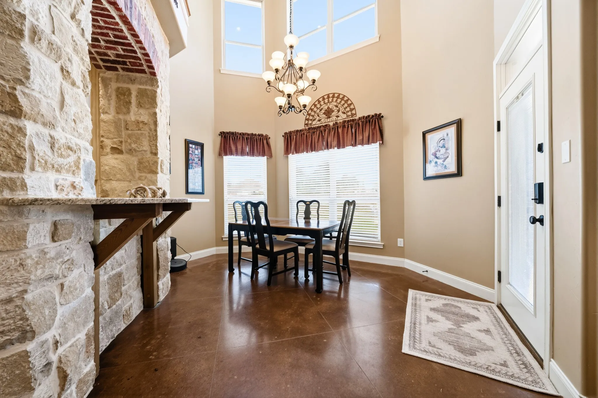 Stonework archway with a granite-finish countertop, high ceilings, large upper windows, and dark wood-finish flooring
