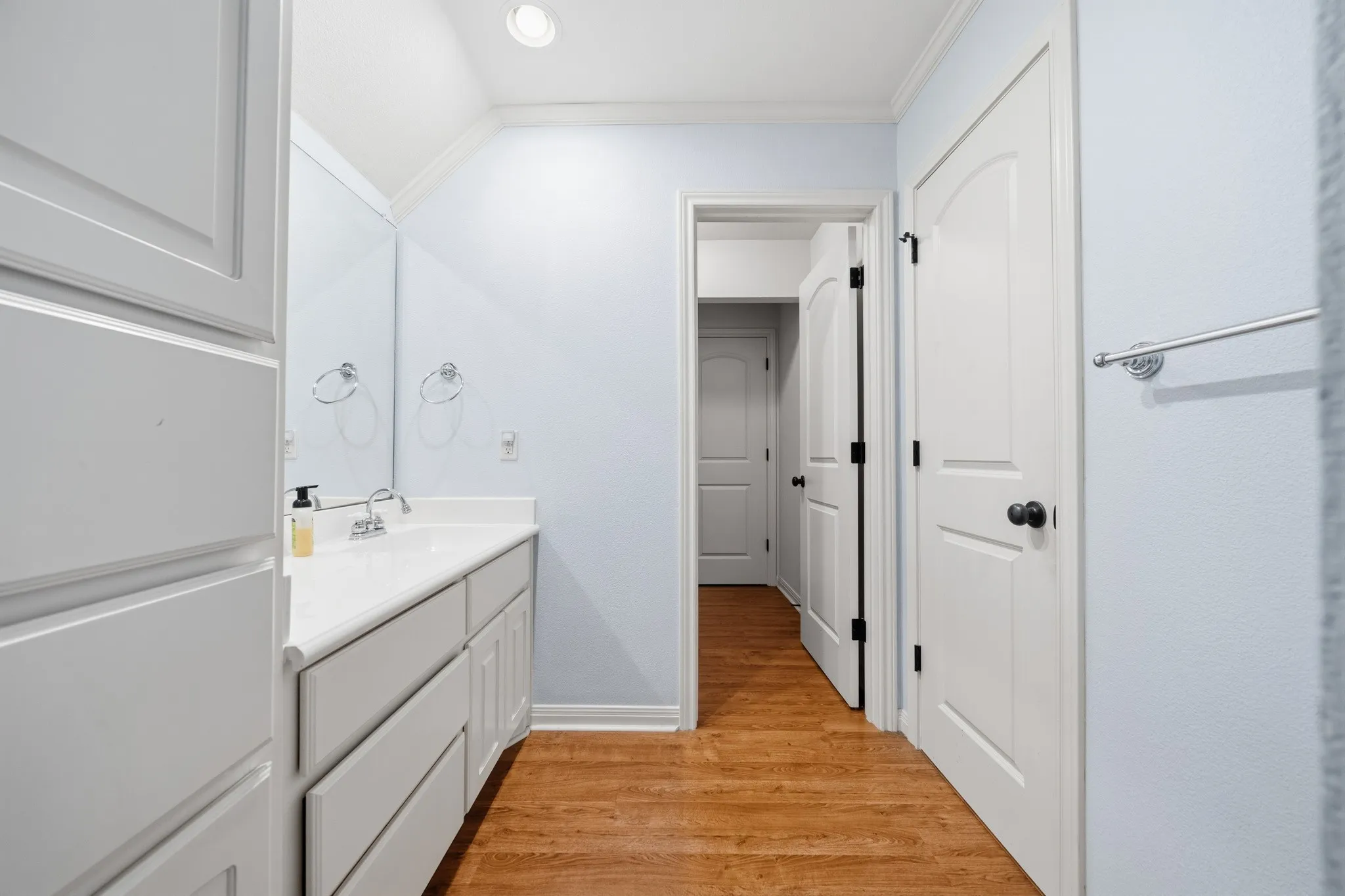 Vanity with integrated sink, white cabinetry, wood-finish flooring, and recessed lighting