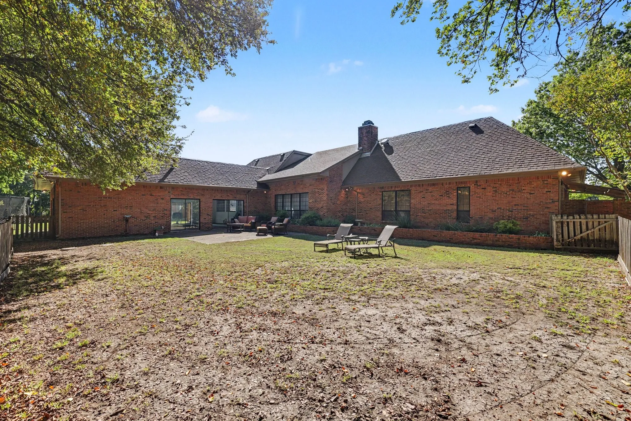 Brick exterior with a shingle roof and multiple windows