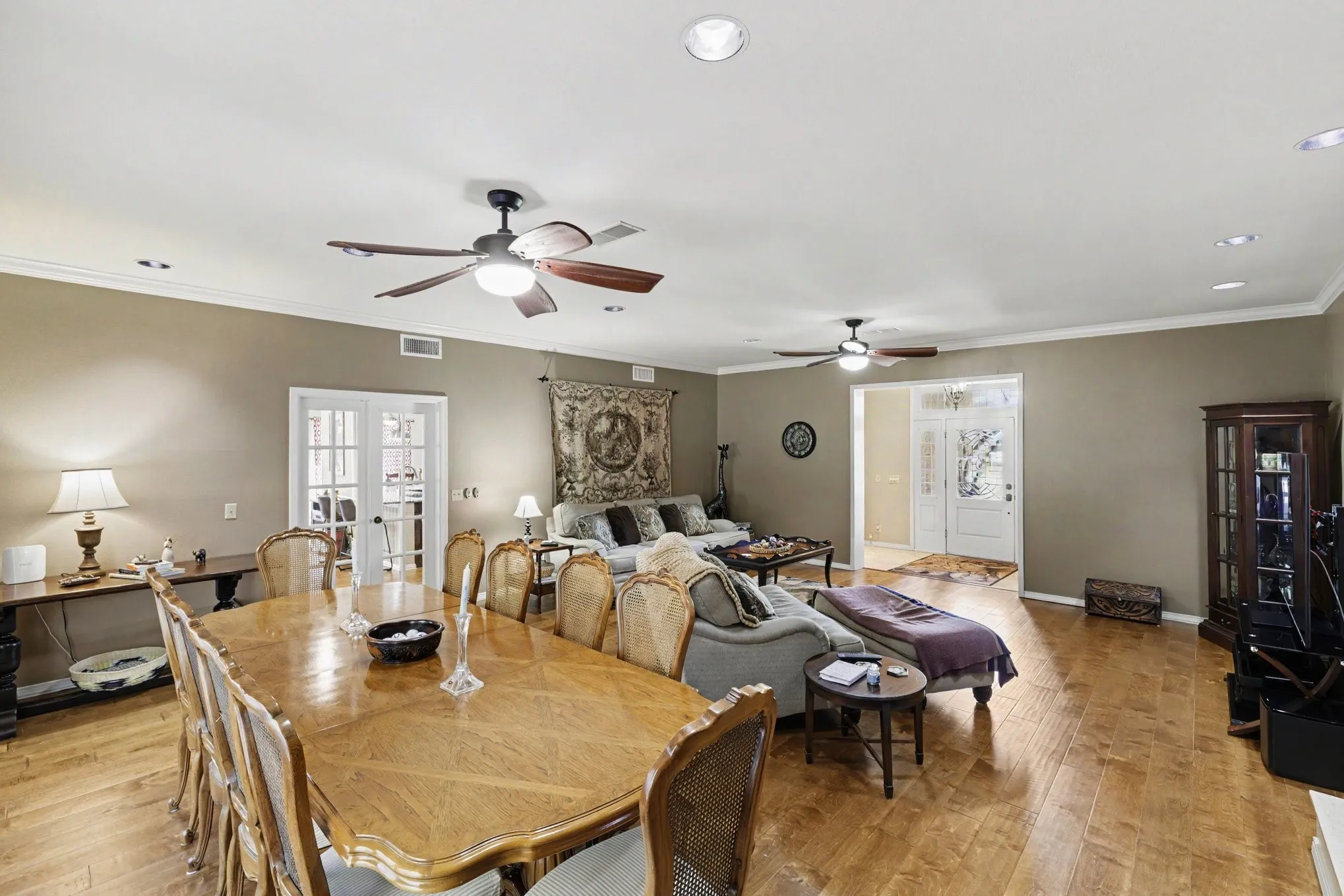 Wood-finish flooring, recessed lighting, crown molding, and multiple ceiling fans