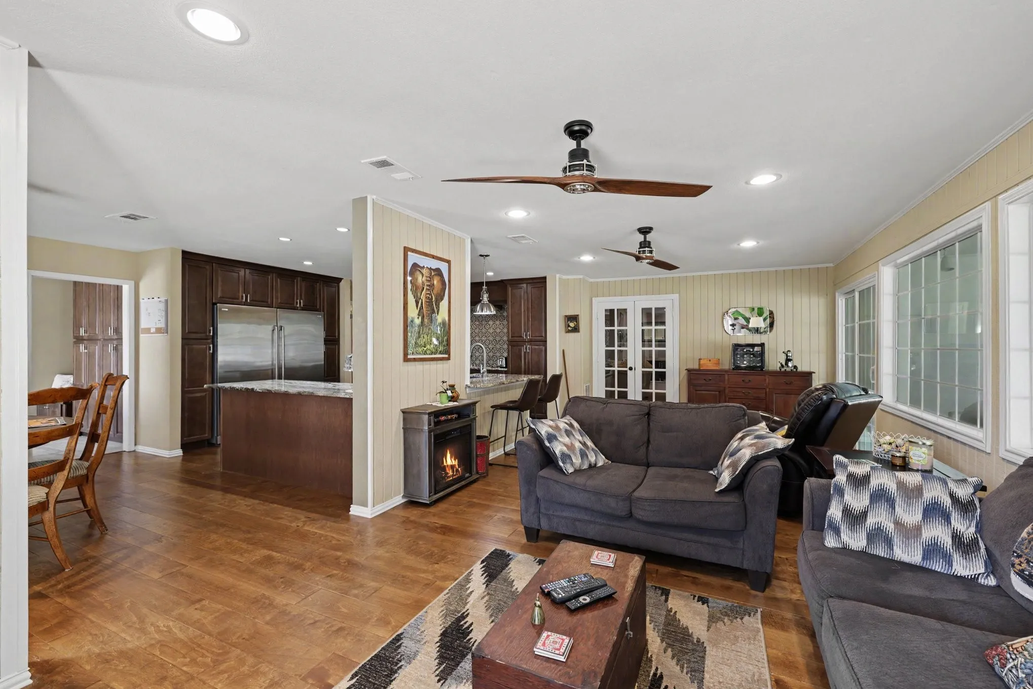 Wood-finish flooring throughout, recessed ceiling lighting, and multiple windows providing ample natural light