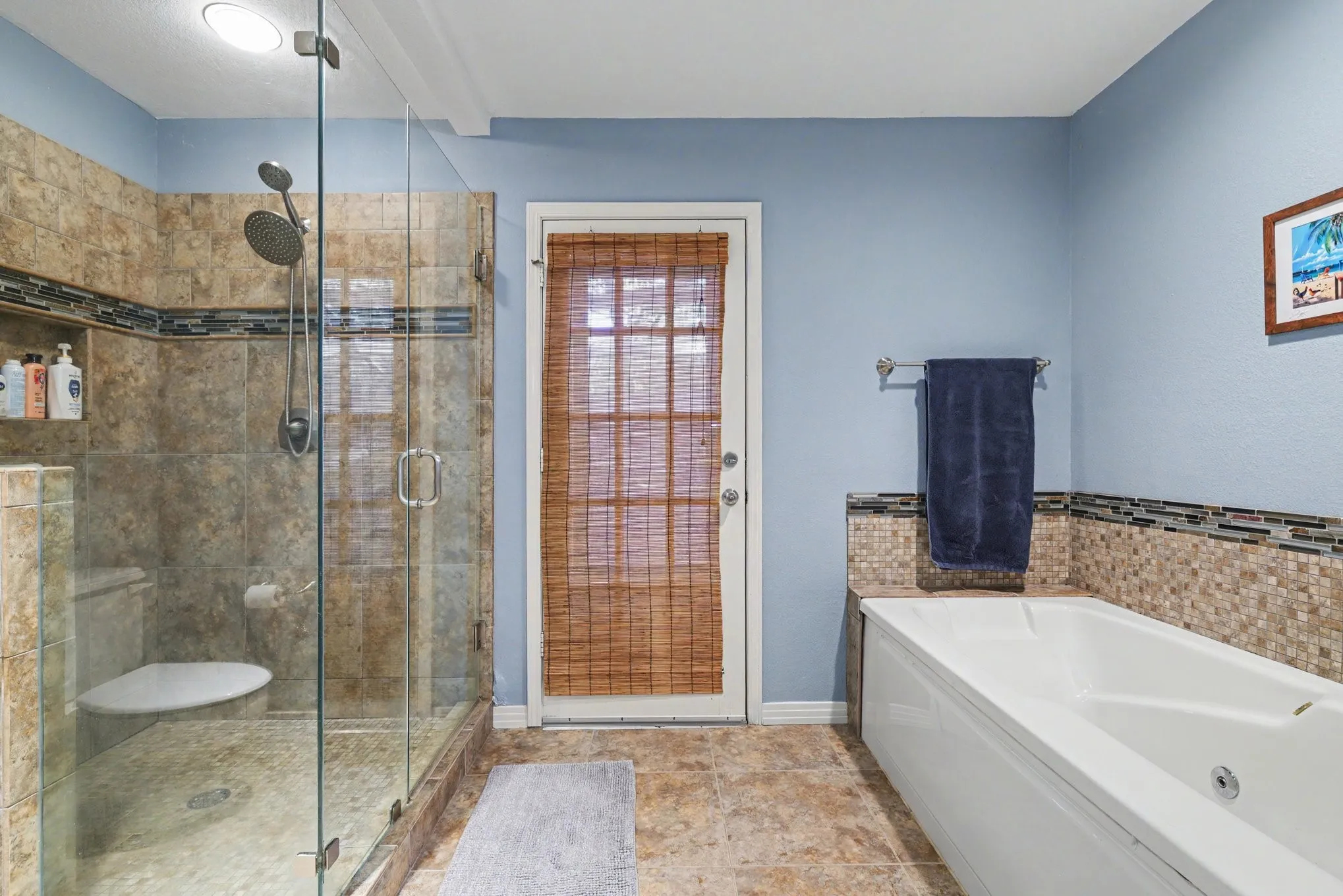 Glass-enclosed shower with multiple showerheads, recessed lighting, and a built-in shelf