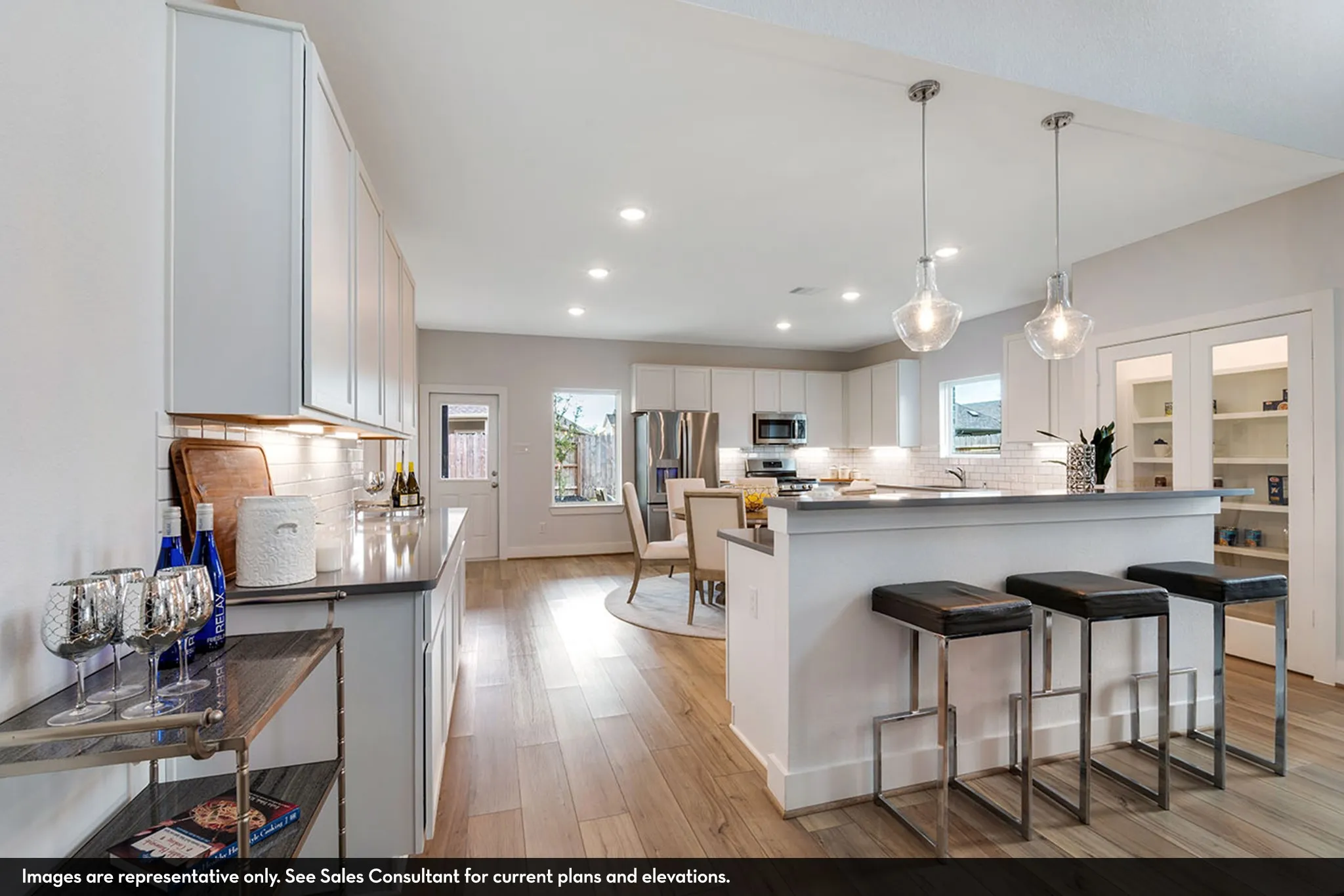 Modern kitchen featuring wood-finish flooring, white cabinetry, recessed lighting, and stainless steel appliances