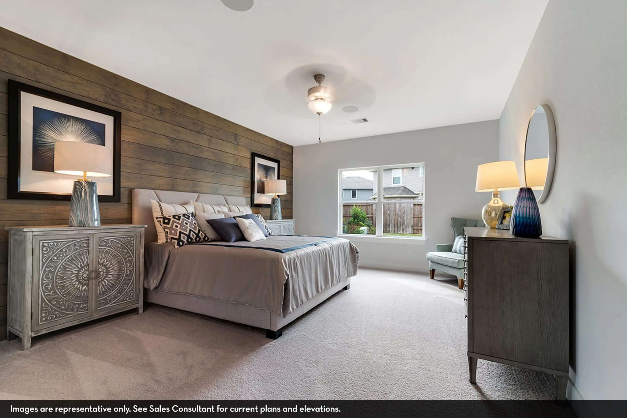 Accent wall featuring wood-finish paneling, soft gray carpeting, and a ceiling fan with integrated lighting
