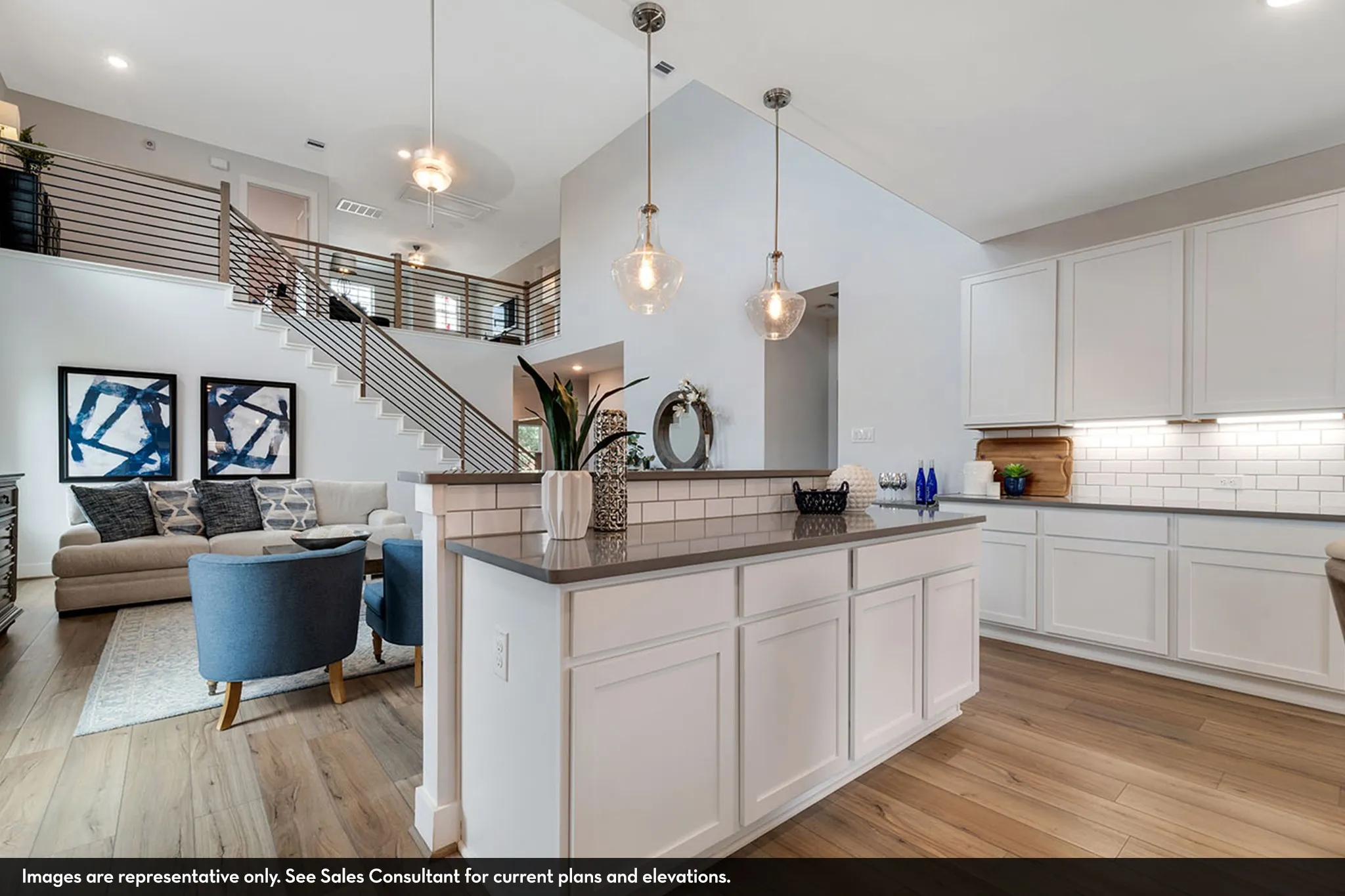 Open-concept living space featuring wood-finish flooring, a kitchen island with pendant lighting, white shaker cabinetry, and a subway tile backsplash