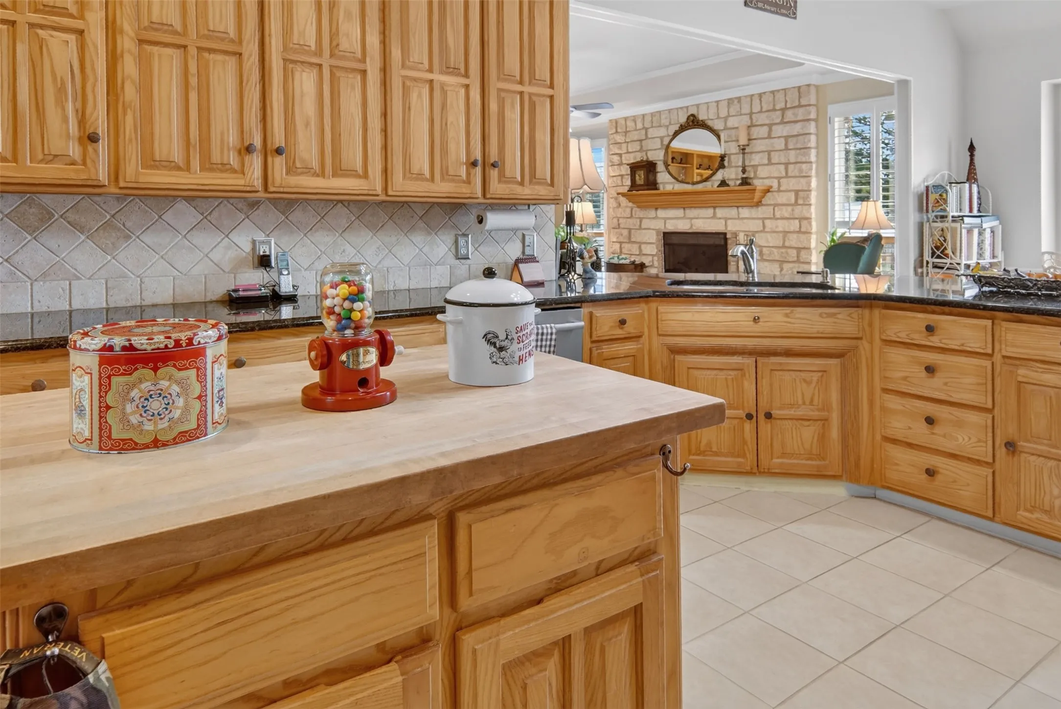 Wood cabinetry with panel doors, solid surface countertops, tile flooring, and a tile backsplash
